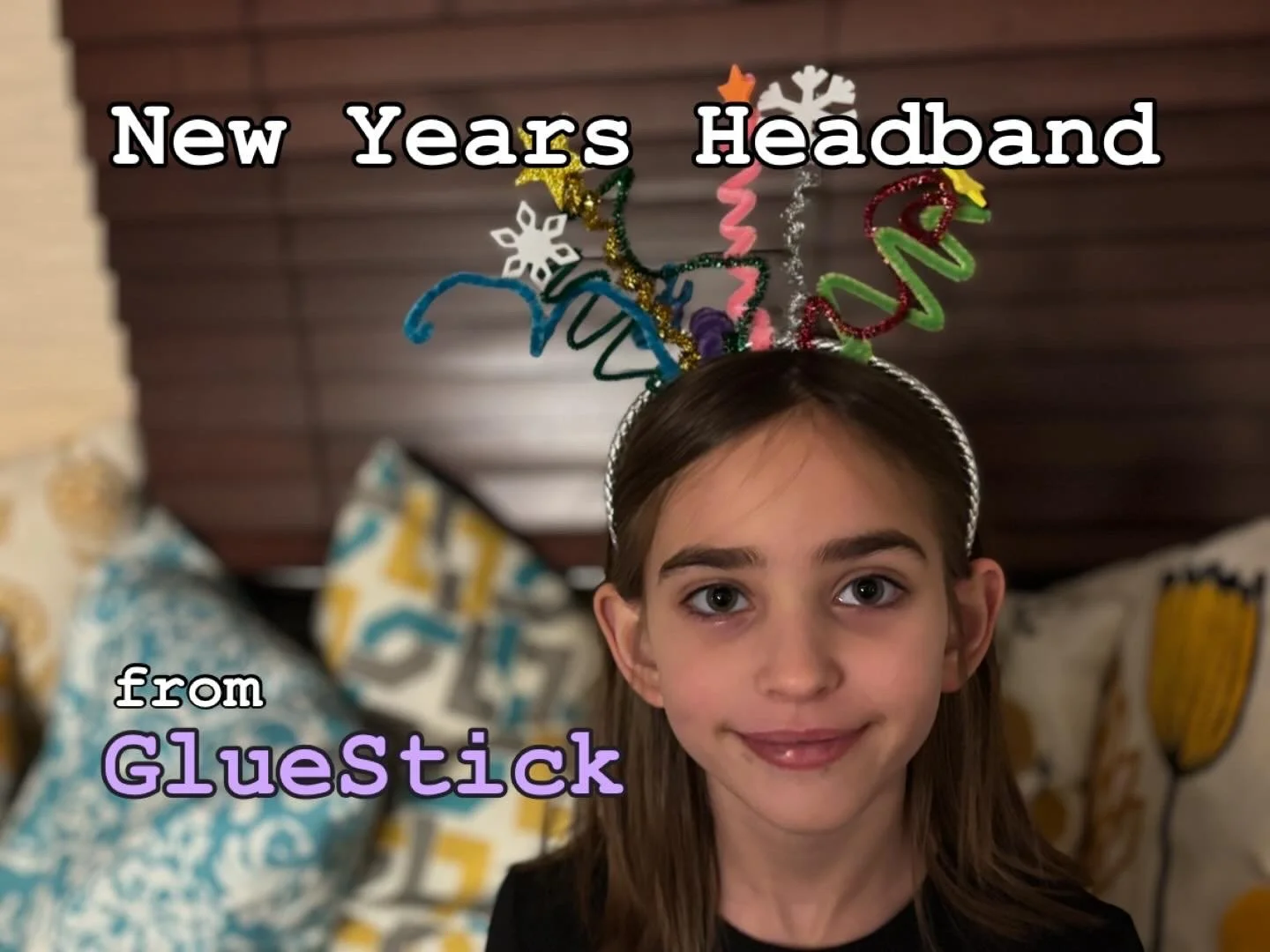 A girl wearing a pipe cleaner fireworks head band with the next "New Years Headband from GlueStick"