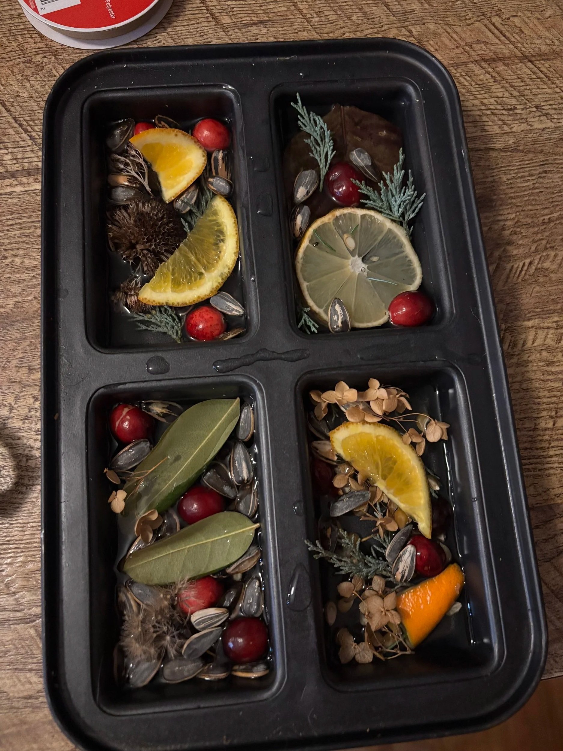 A mini-bread loaf pan filled with water and natural ingredients before being frozen into ornaments.