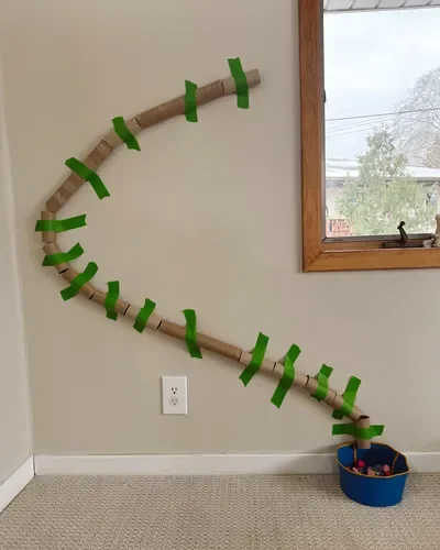 A pom pom luge made from cardboard tubes