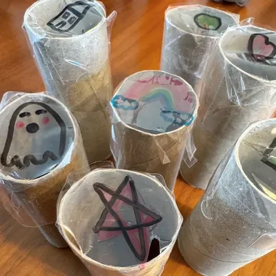 Toilet paper tubes covered with wax paper that has been drawn on. Shining a light through the tube will cast a shadow of the drawing.