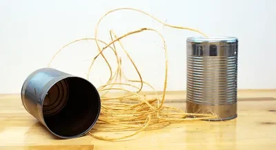 A tin can telephone experiment made from two empty soup cans and twine