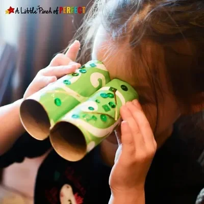 A girl uses leprechaun-spotting binoculars she made.