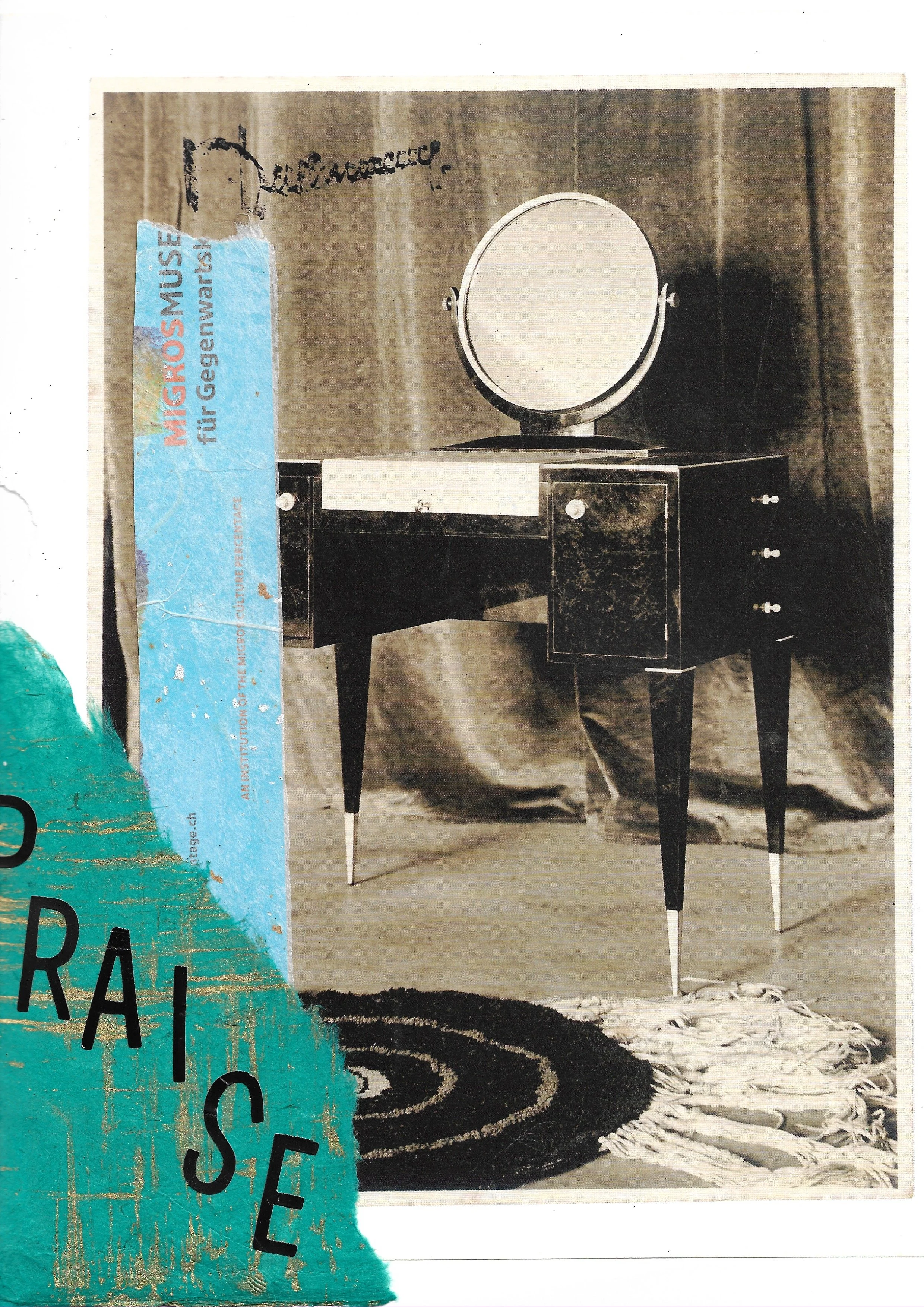 Black and white image of a black vanity with a circular mirror and pointed legs. Blue paper with stickers writing "PRAISE" on the left. 