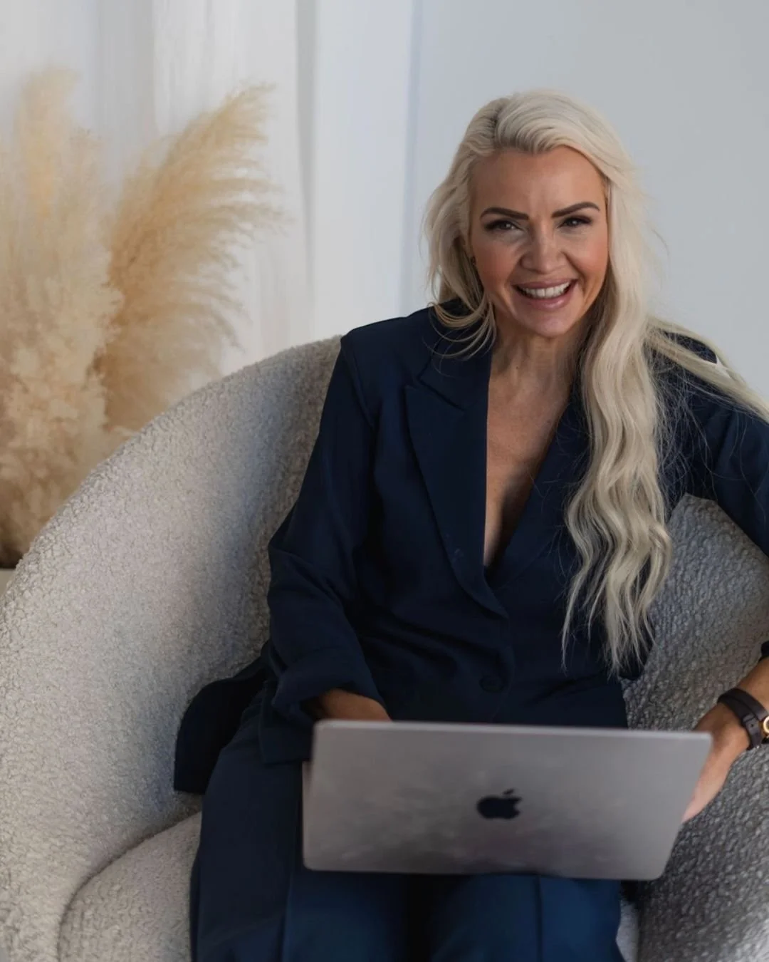 IMAGOsettersin toimitusjohtaja Mari Huhtamäki istuu tietokone sylissään.