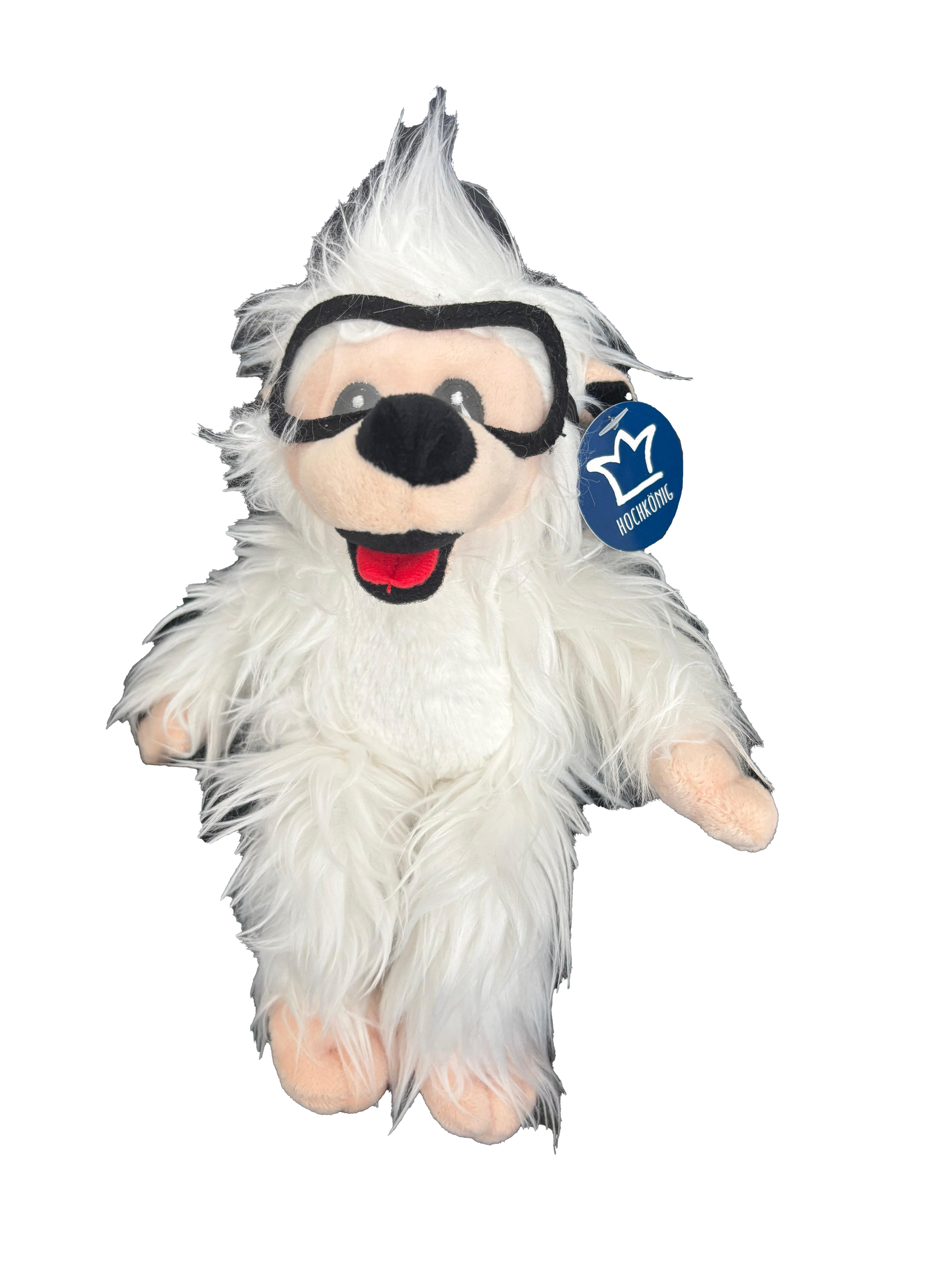 Ein flauschiges Plüschtier eines weißen, haarigen Igels mit Brille und einem blauen Anhänger, der die Marke Hochkönig Bergbahnen trägt.