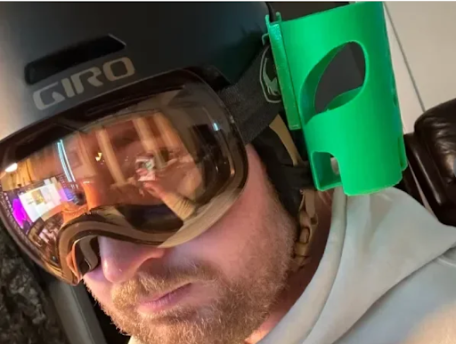 Beer can holder mounted on a ski helmet