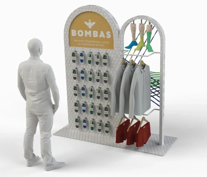 Display rack with socks, coats, and jackets, labeled 'BOMBAS' as the most comfortable socks in history of feet, with a person browsing the store.