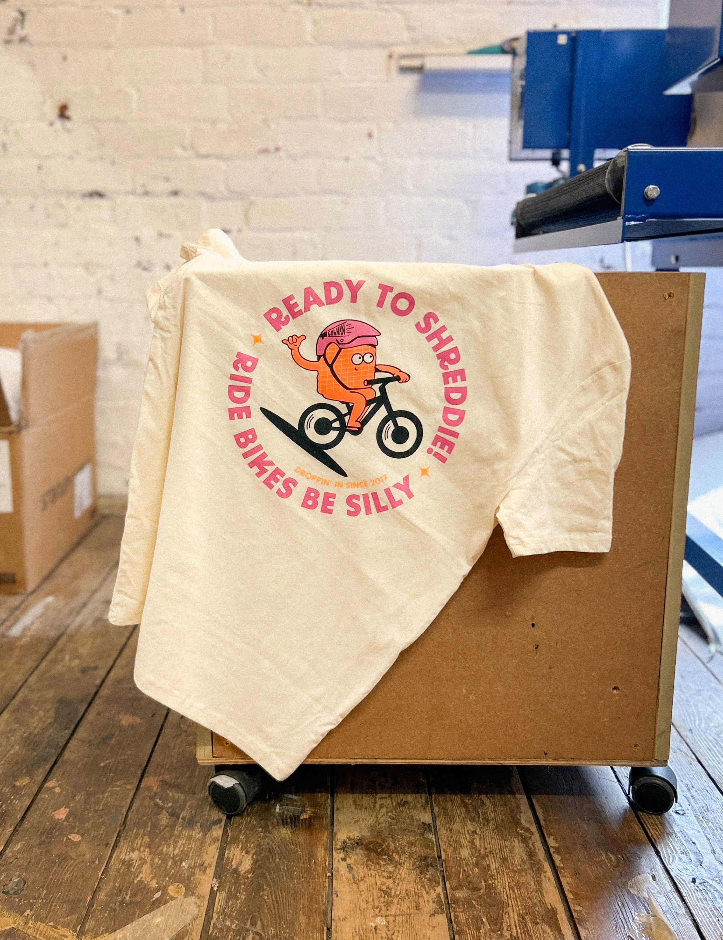 A multi-colour screen print on to natural, undyed, 100% organic cotton t-shirts.