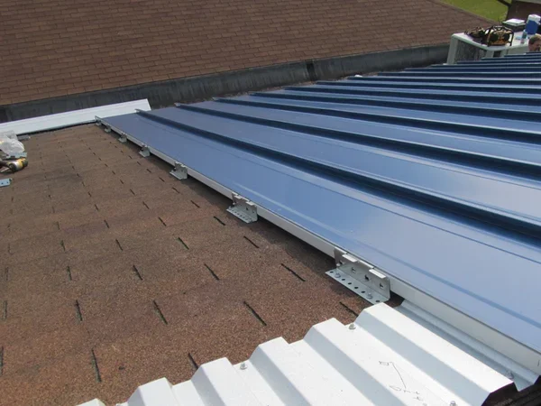 Shingle roof with metal roof panel on top