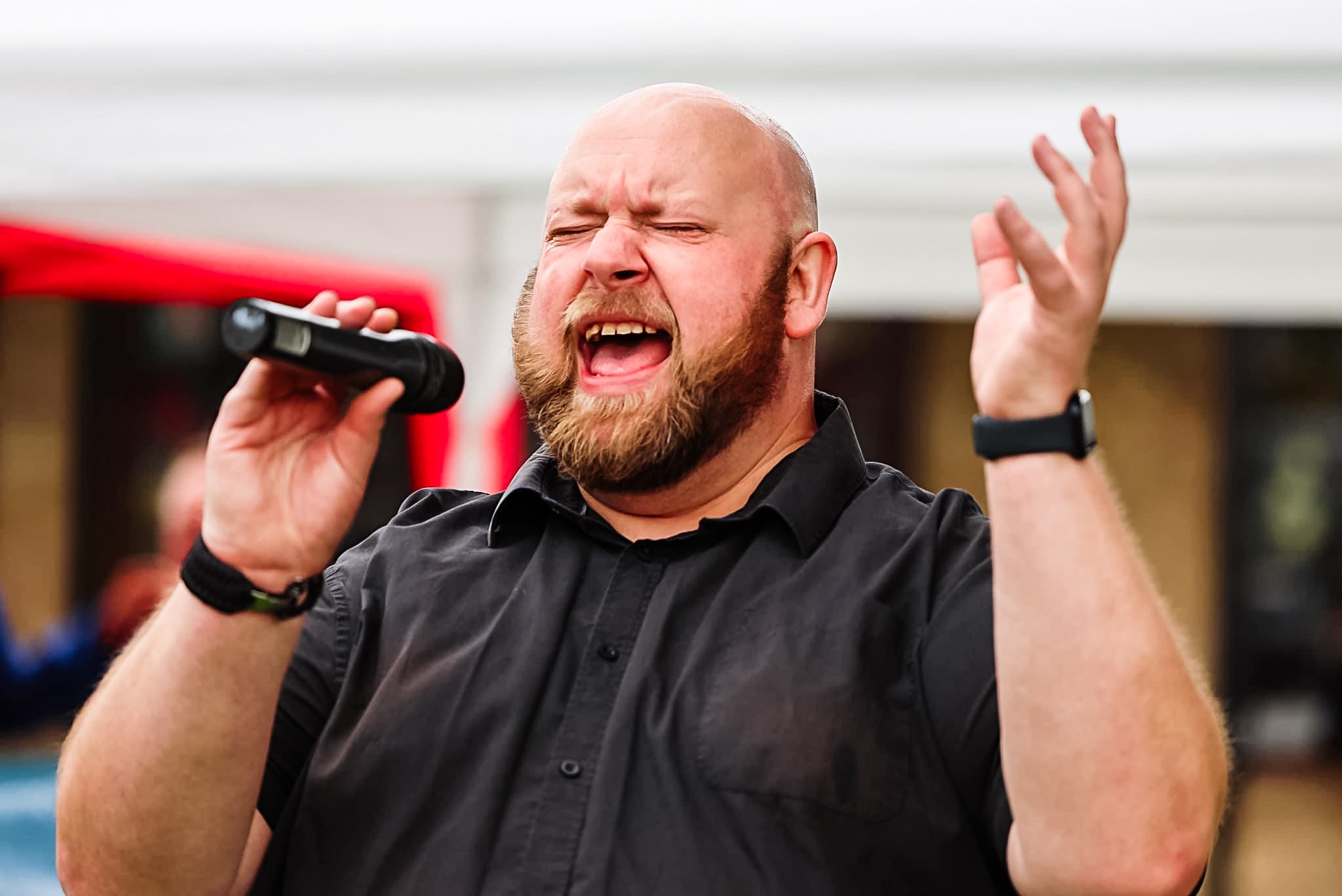 Man singing into a microphone outdoors