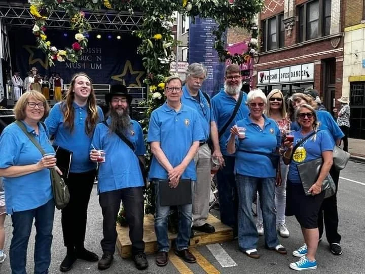 An assortment of chorus members pose for a photo in front of the stage where they performed earlier that day.