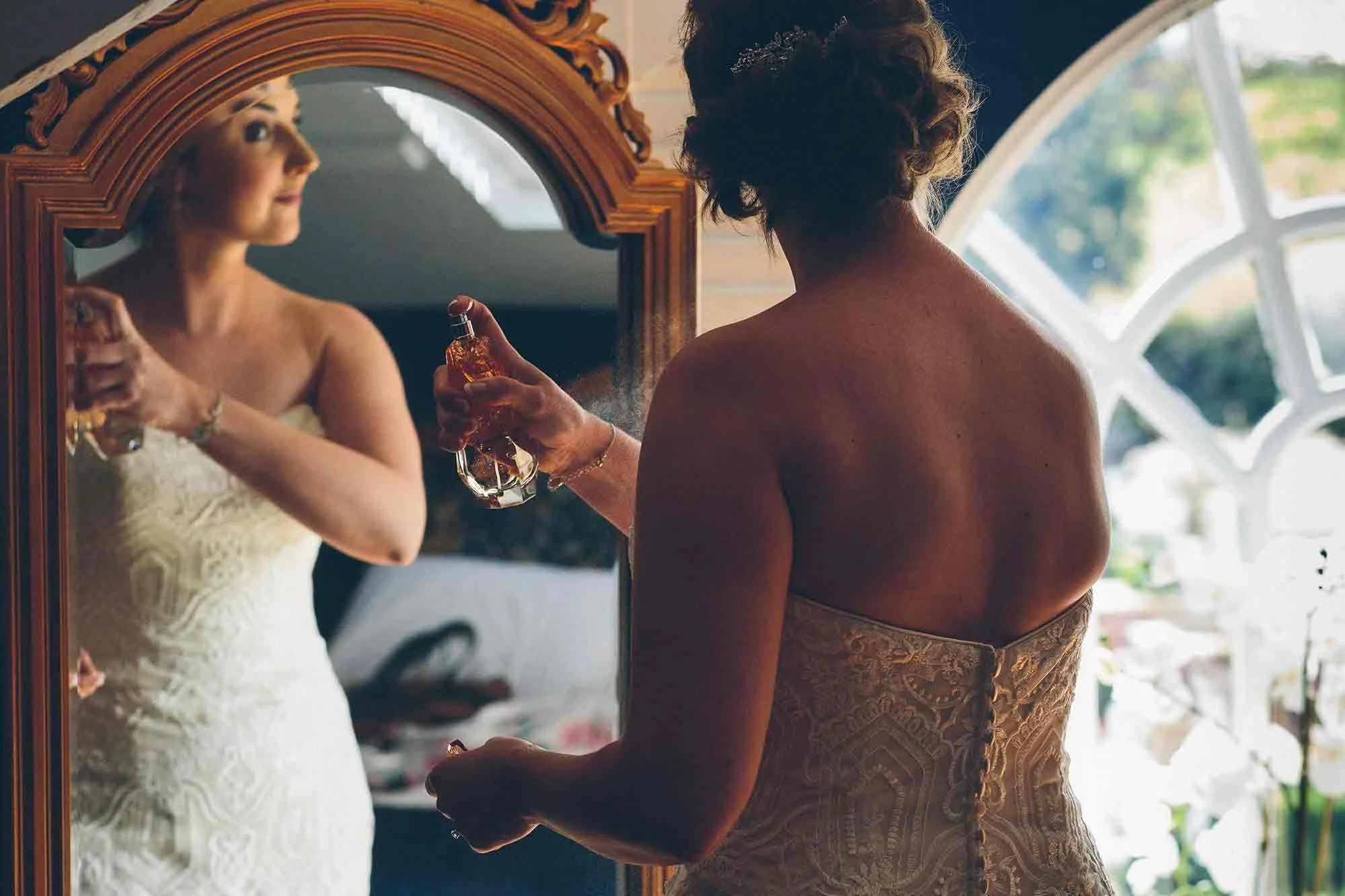 The bride spraying perfume right before her wedding ceremony at Woodhill Hall in Northumberland.