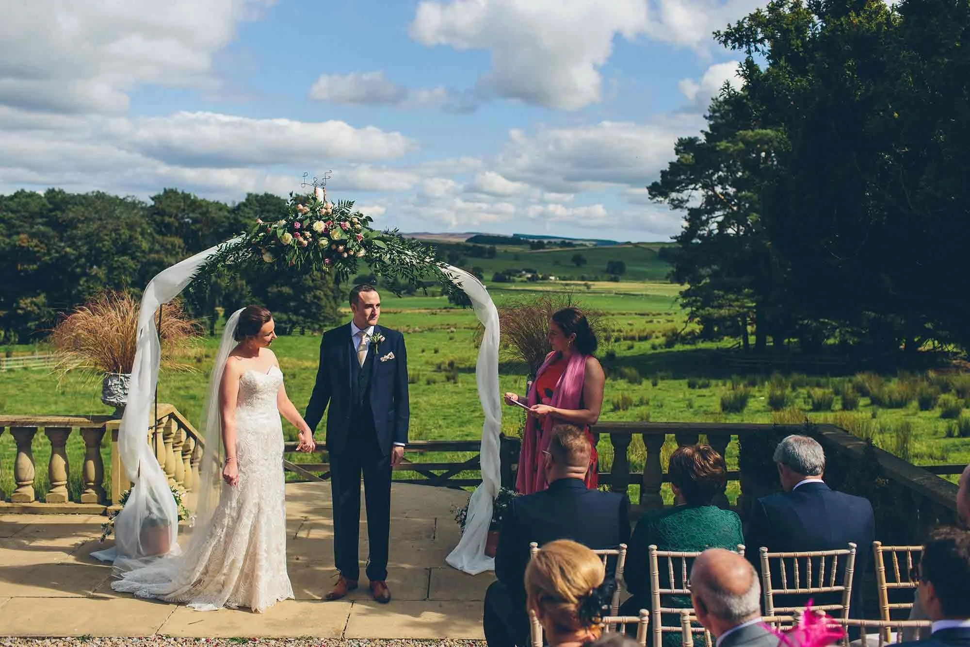 A guest gives a reading at an outdoor wedding at Woodhill hall.