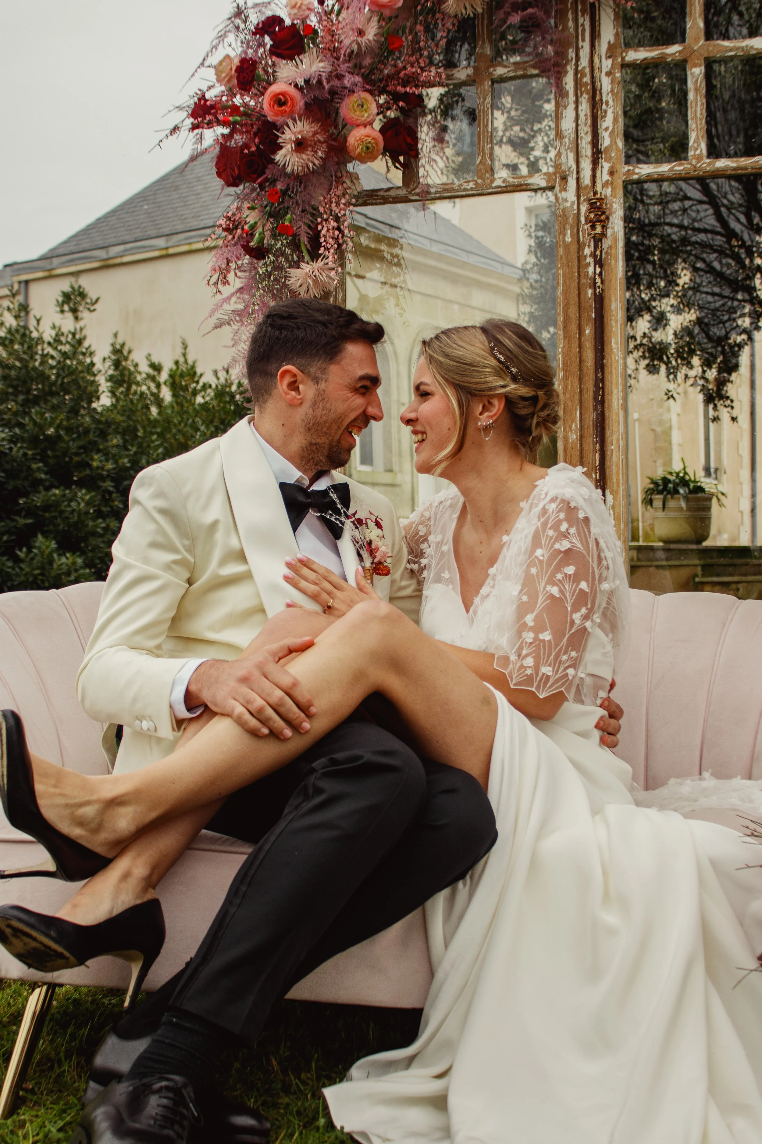 Séance photo de couple pendant le mariage devant le château avec des fleurs bisous esquimaux complicité et amour à Seclin