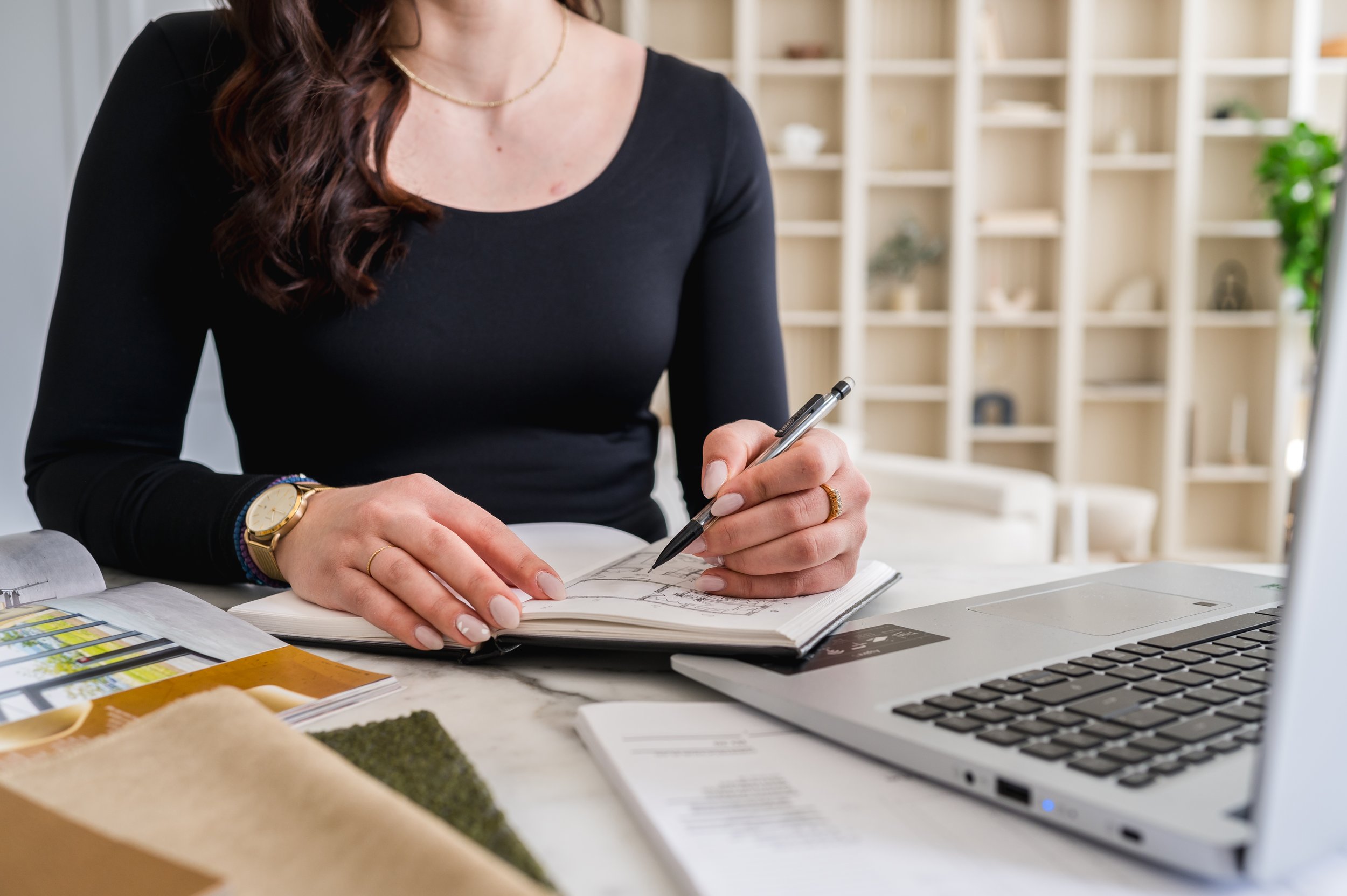 Working at desk with laptop, sketchbook and finish samples