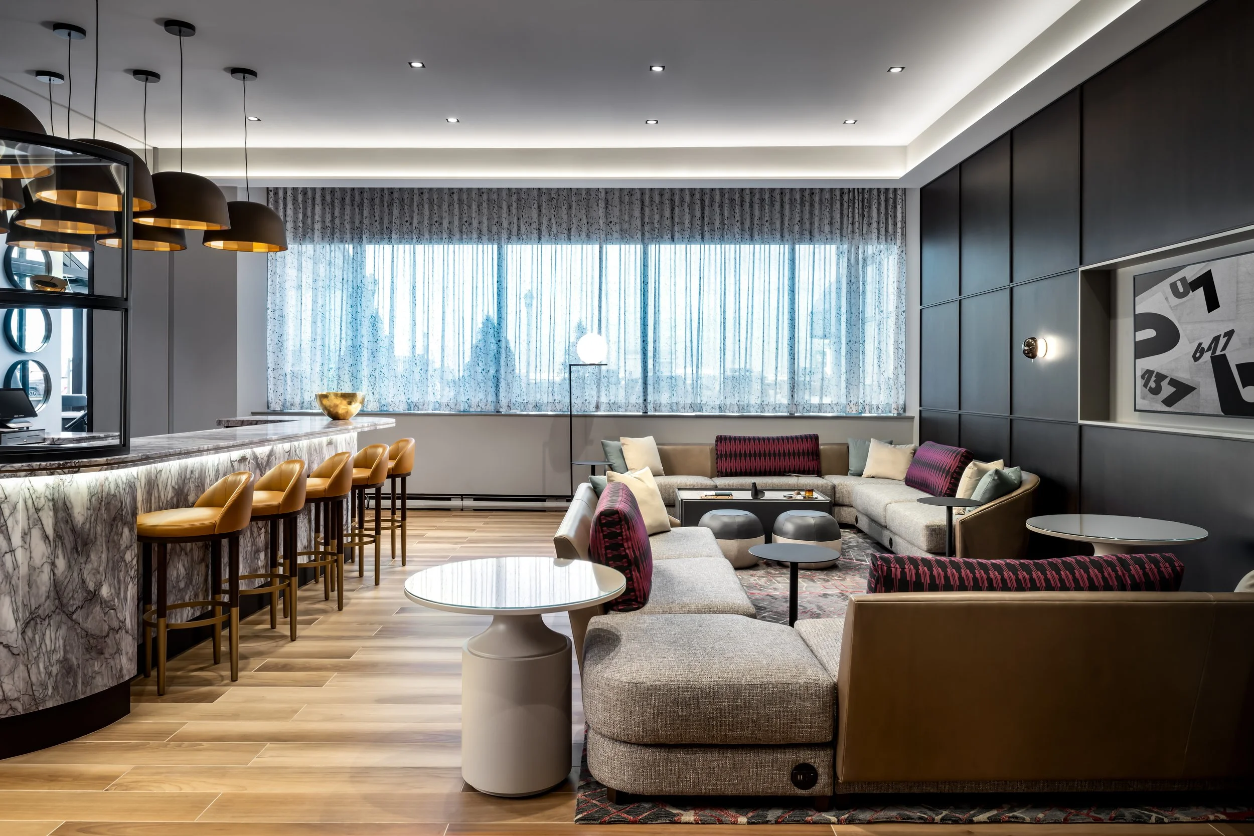 Club lounge seating area with wood wall panelling adjacent to stone bar