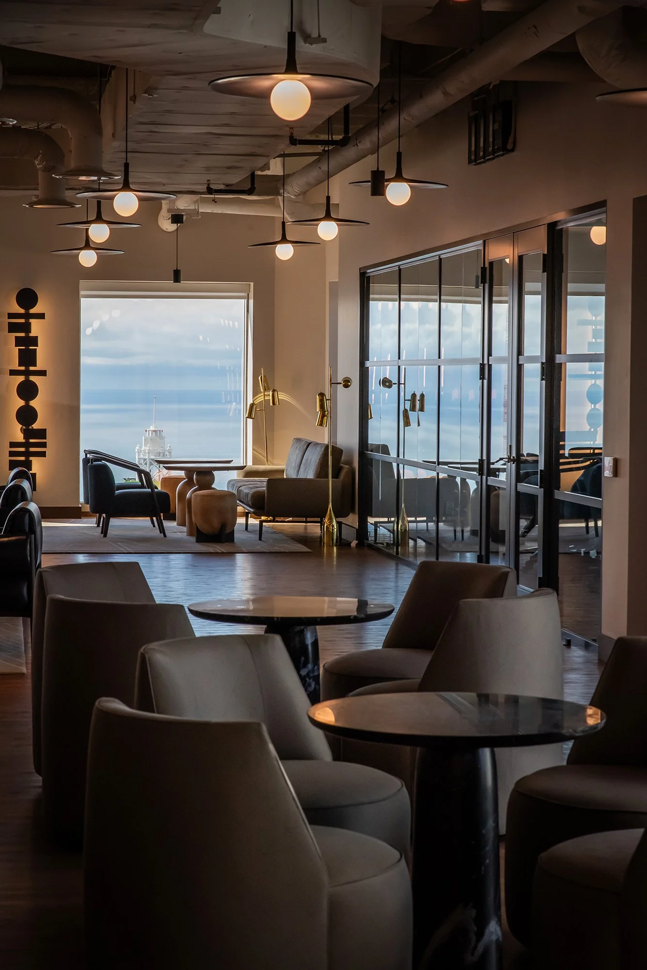 Seating area near window with sculptural wall sconces