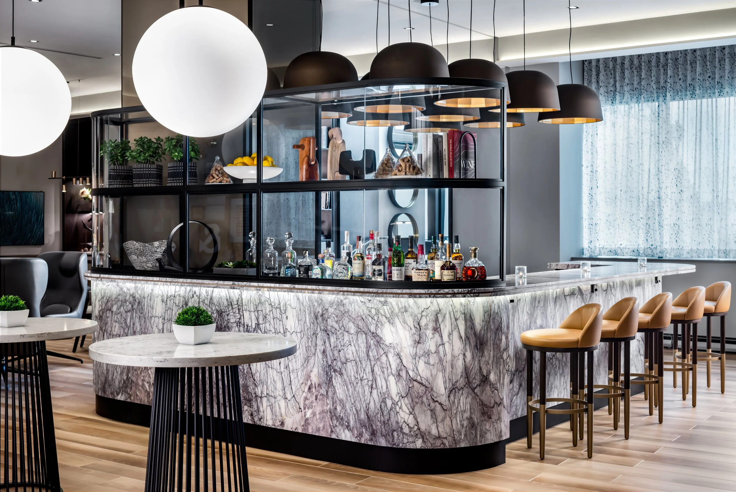 Club lounge stone clad bar with leather stools and liquor display