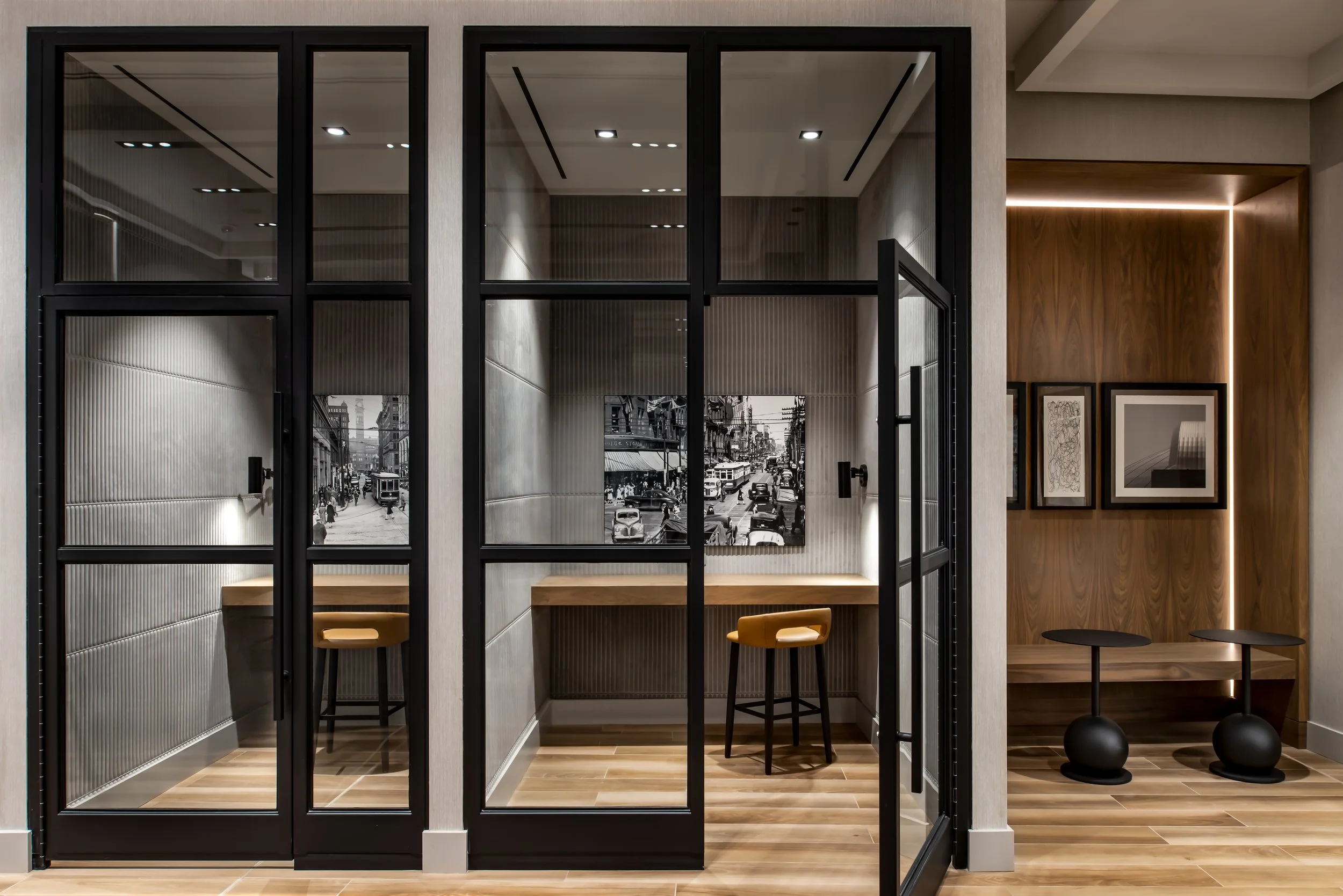 Black metal glazed phone booths with acoustic wall treatments and accent art