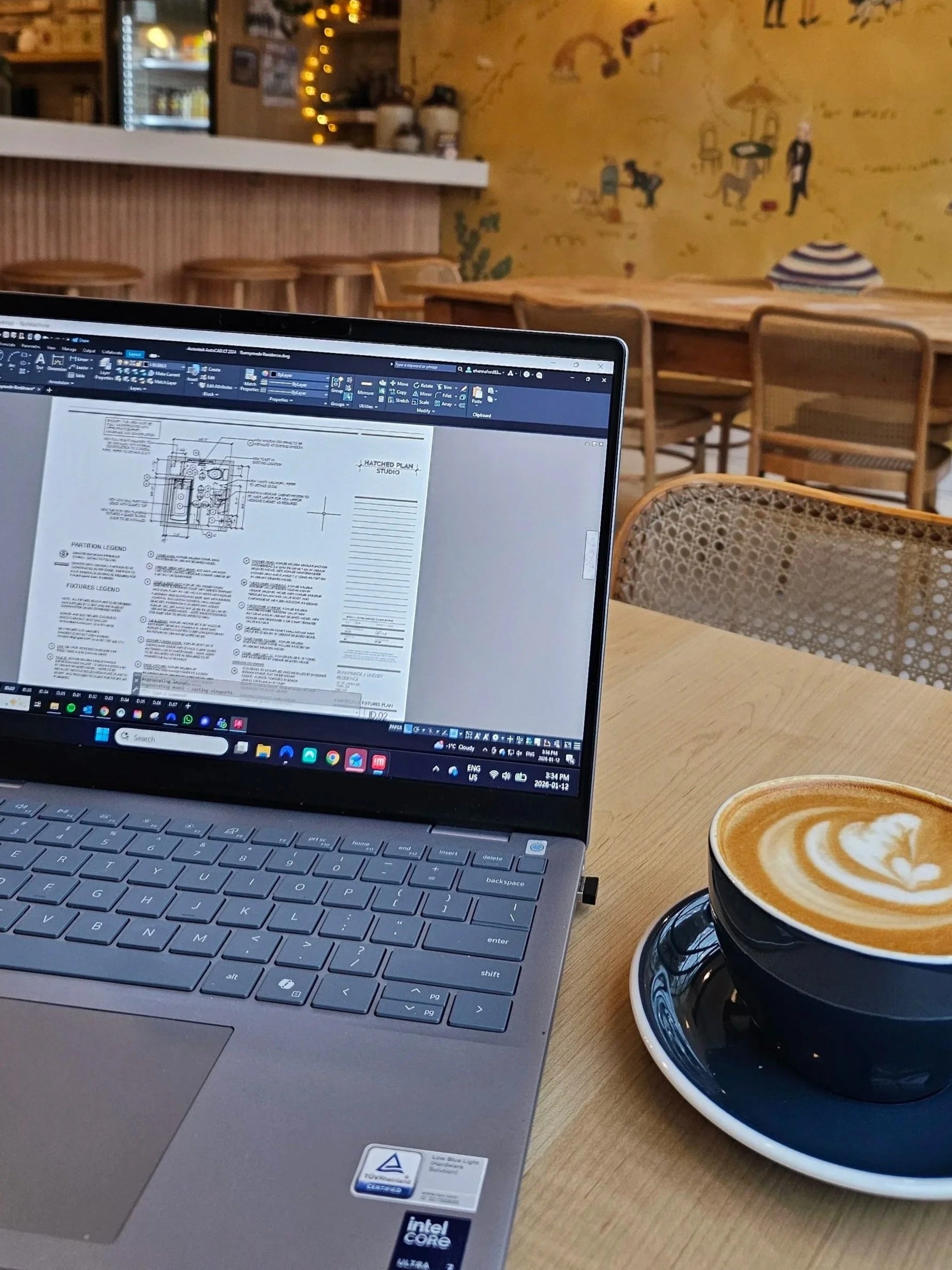 Close up of laptop with drawing set in a coffee shop