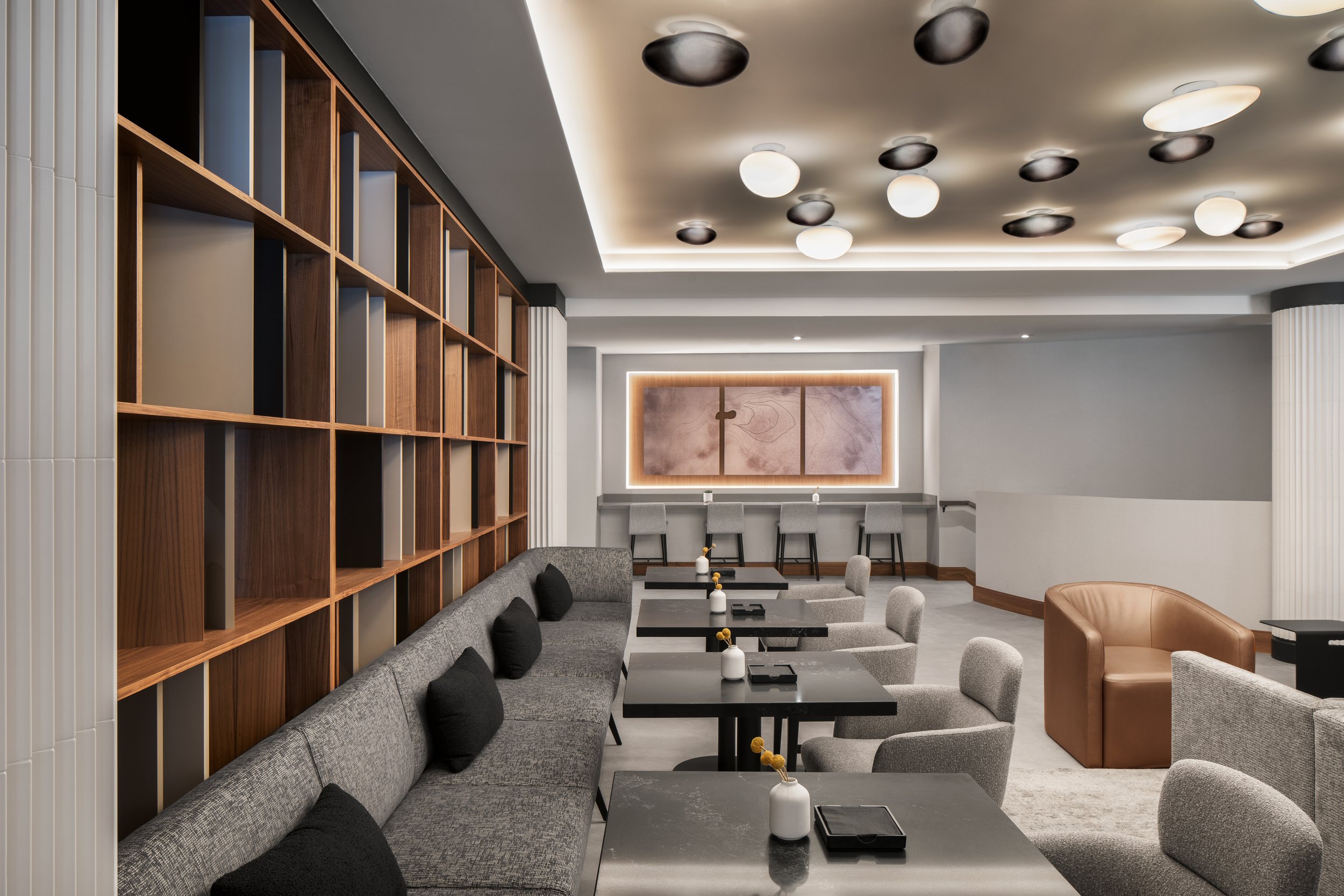 Restaurant upholstered banquette with wood and quartz architectural screen and decorative lighting