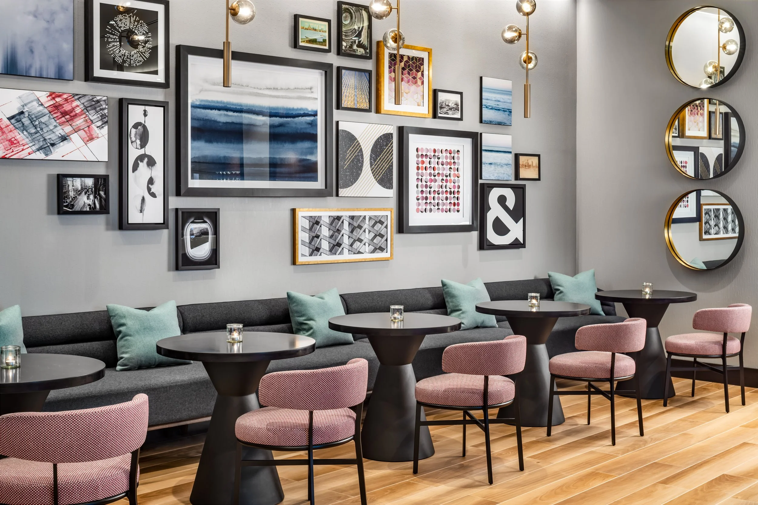 Club lounge interior with large banquette seating and gallery wall art installation