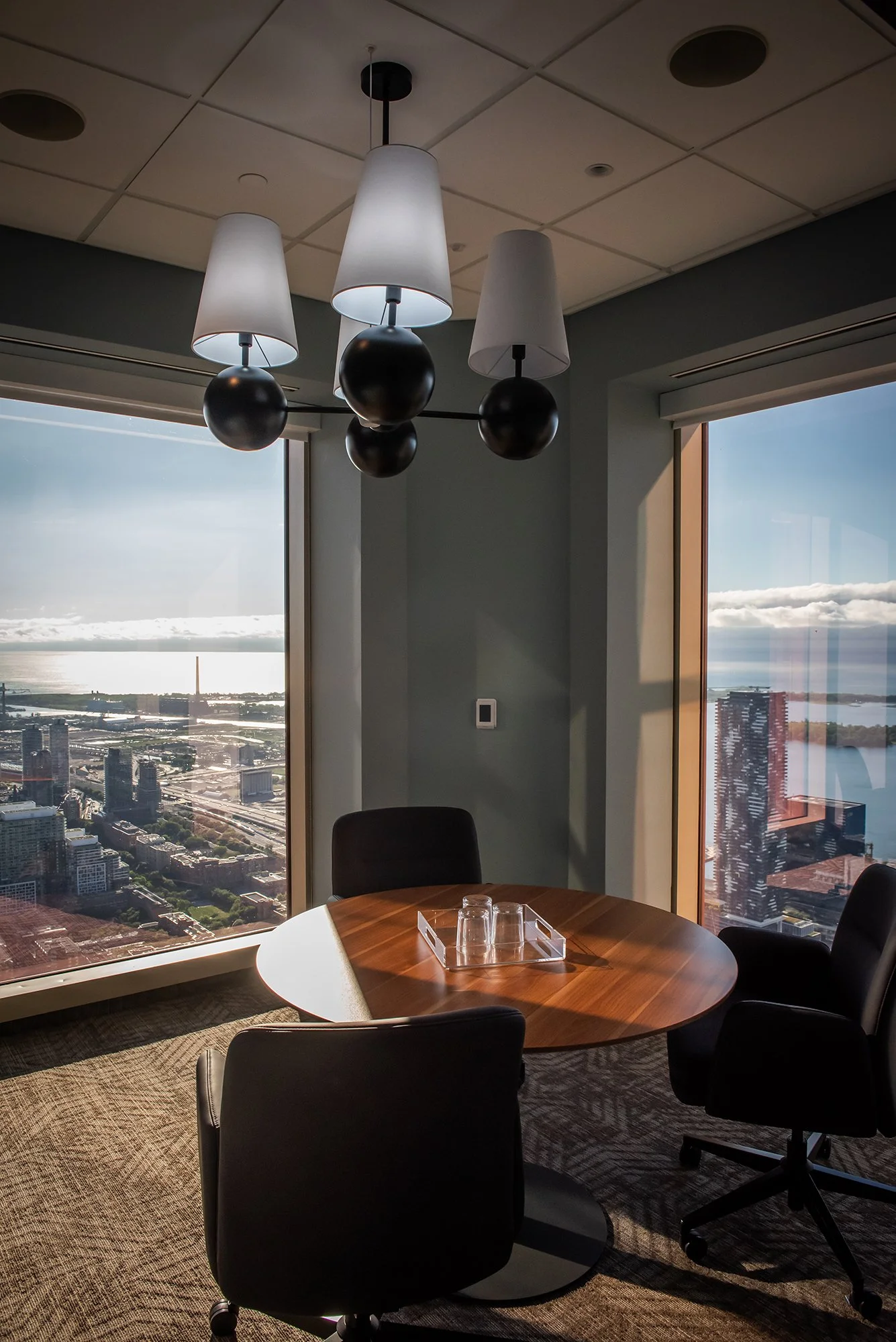 Meeting room with wood boardroom table, chairs and large windows