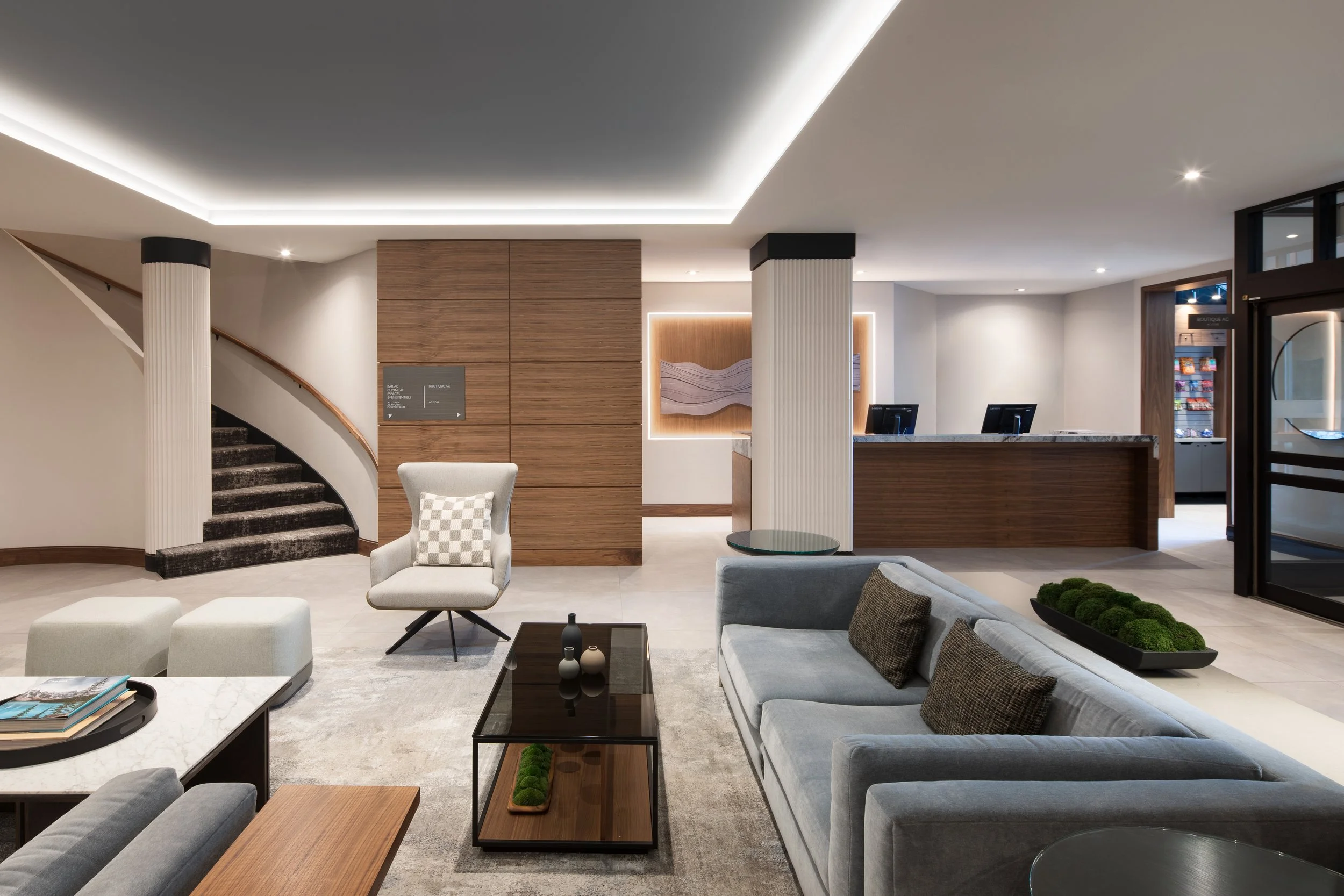 Large seating area with fabric sofas and chairs facing wood and stone front desk