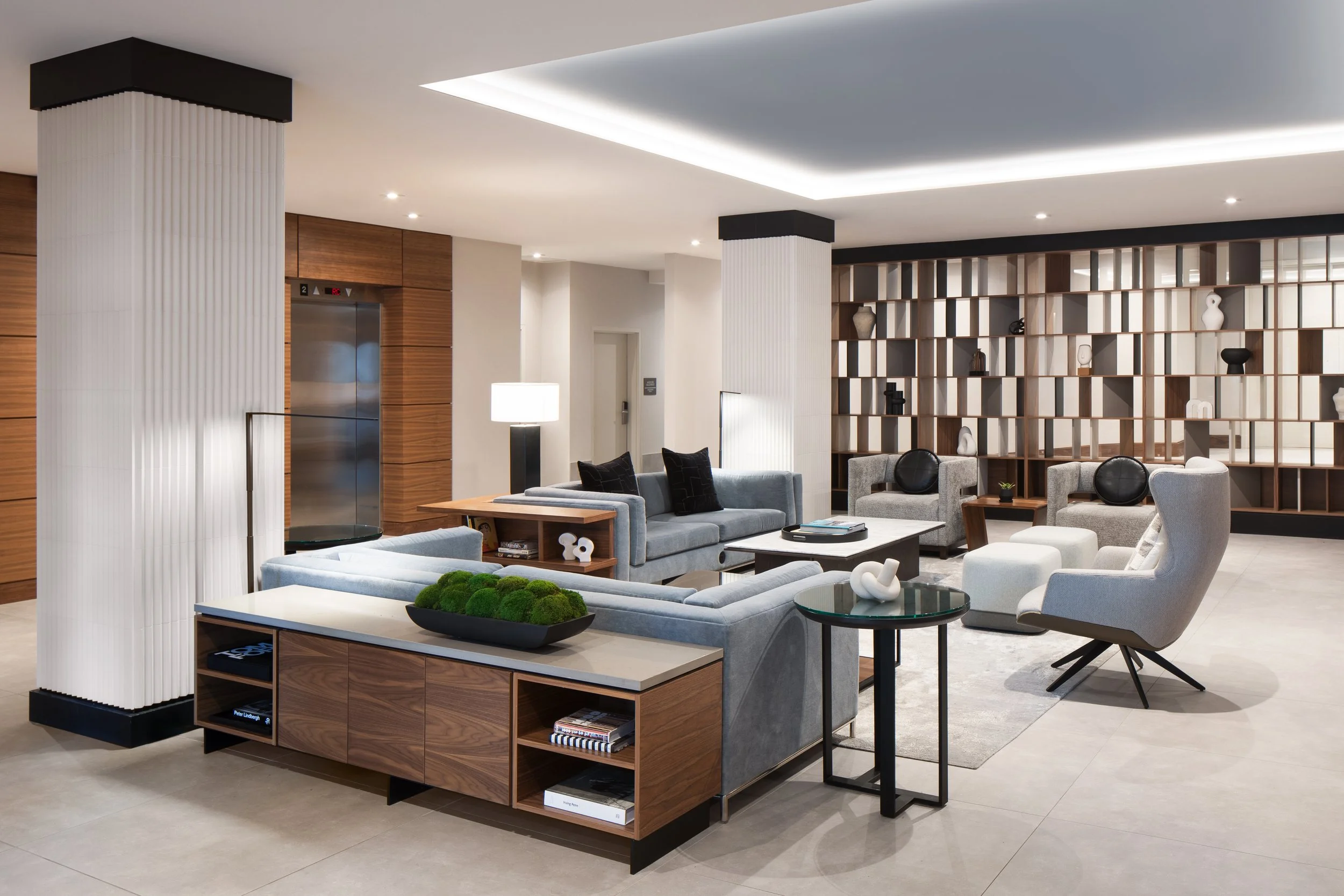 Large seating area with fabric sofas and chairs surrounded by architectural screen and columns