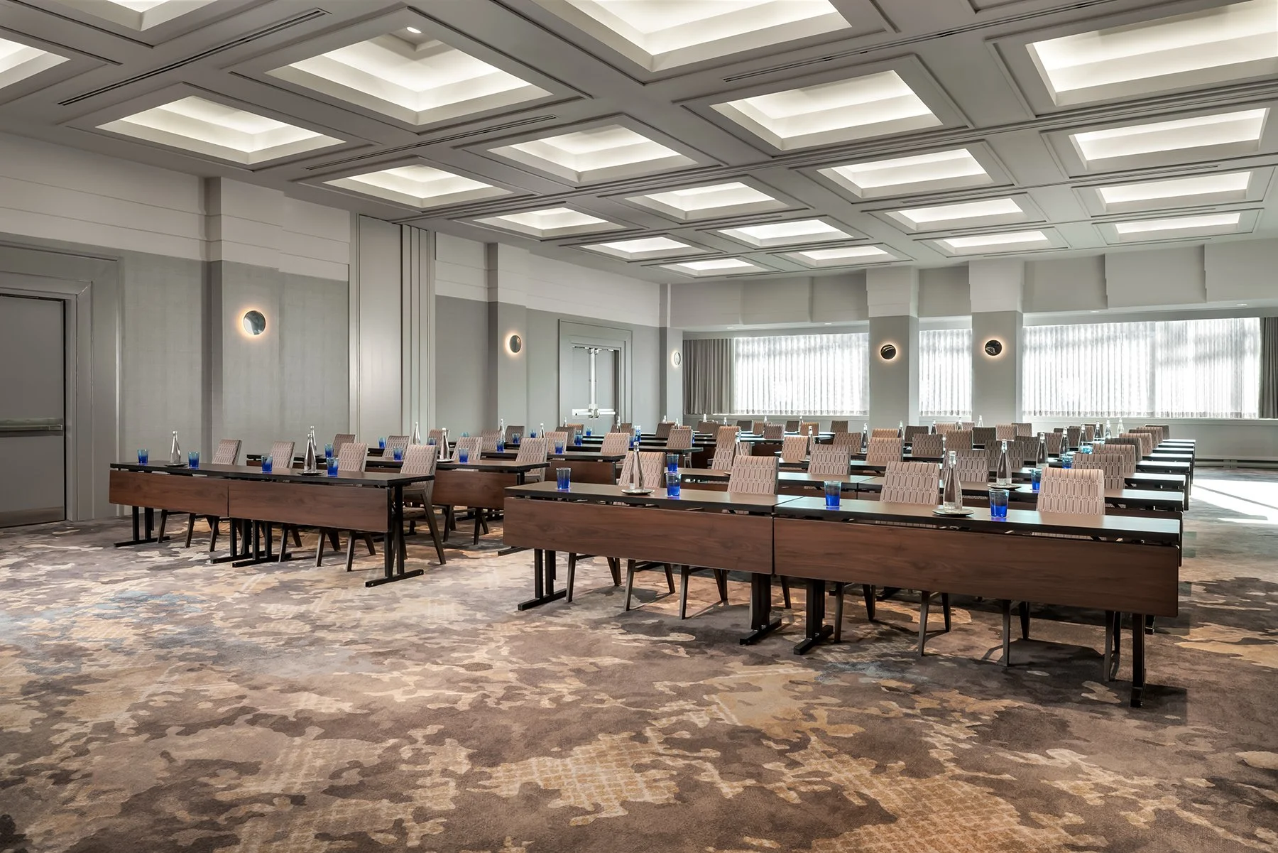 Function space with carpet, coffered ceilings filled with classroom meeting tables