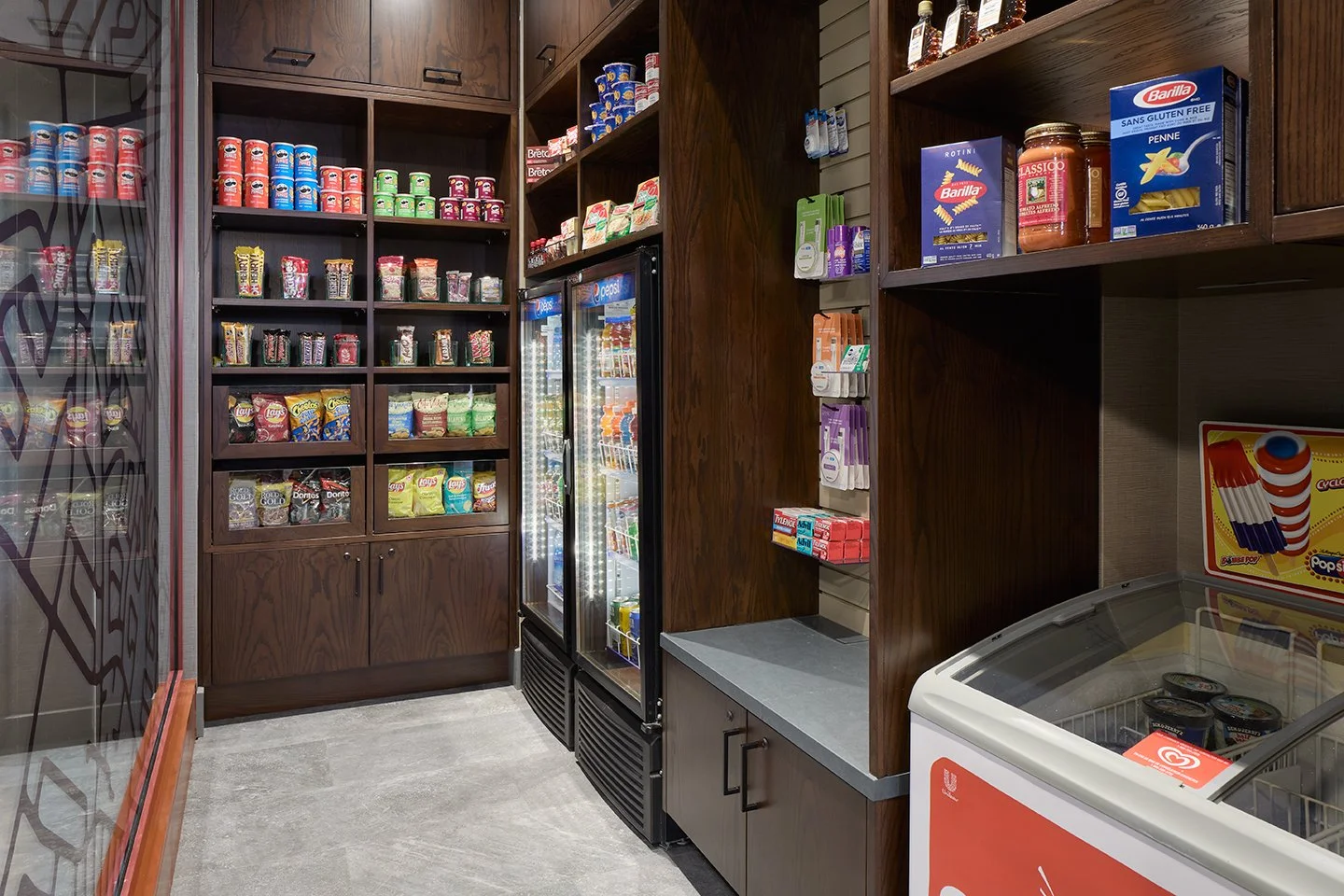 Hotel retail market wood millwork with grey quartz countertops and red decorative screen