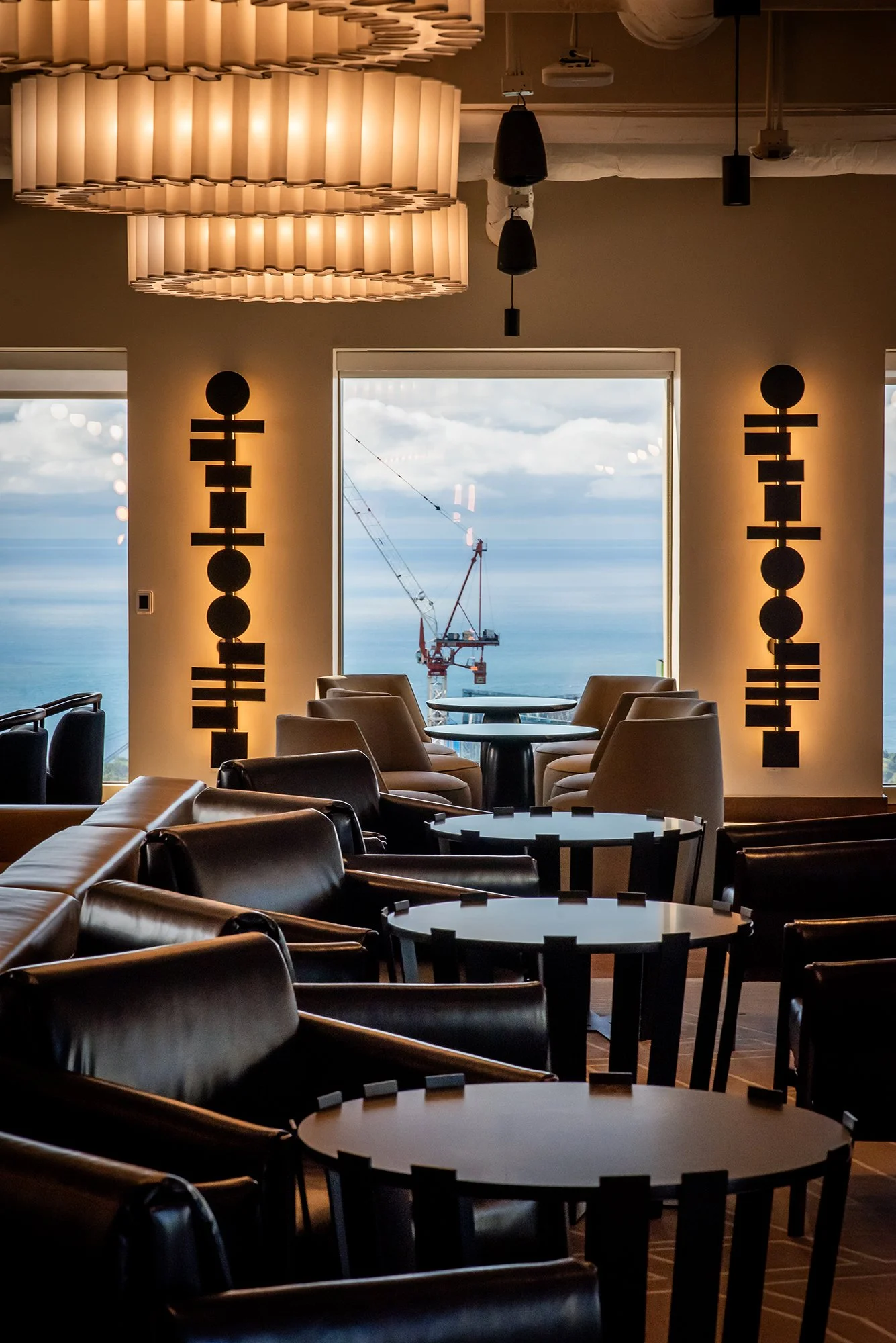 Seating area near window with sculptural wall sconces