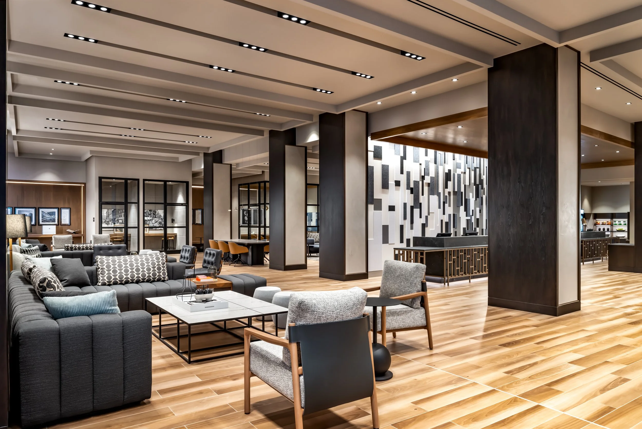 Hotel lobby with various upholstered seating and wood finishes