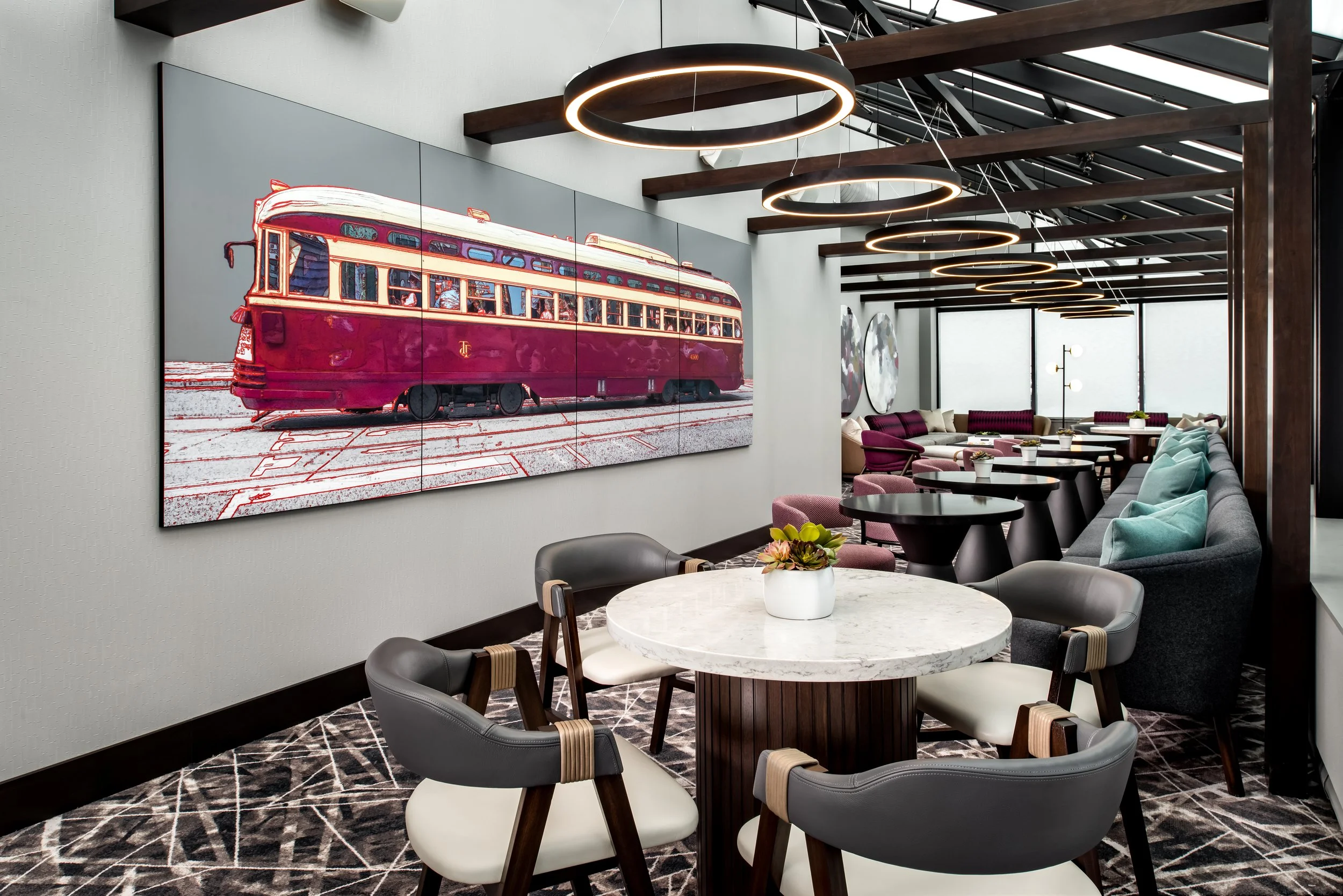 Club lounge solarium space with various seating and feature toronto streetcar art