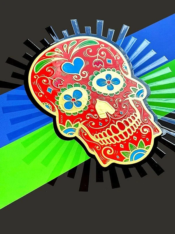 Colorful Day of the Dead sugar skull design with intricate floral and heart patterns on red background, set against a vibrant geometric backdrop of blue, green, and black.