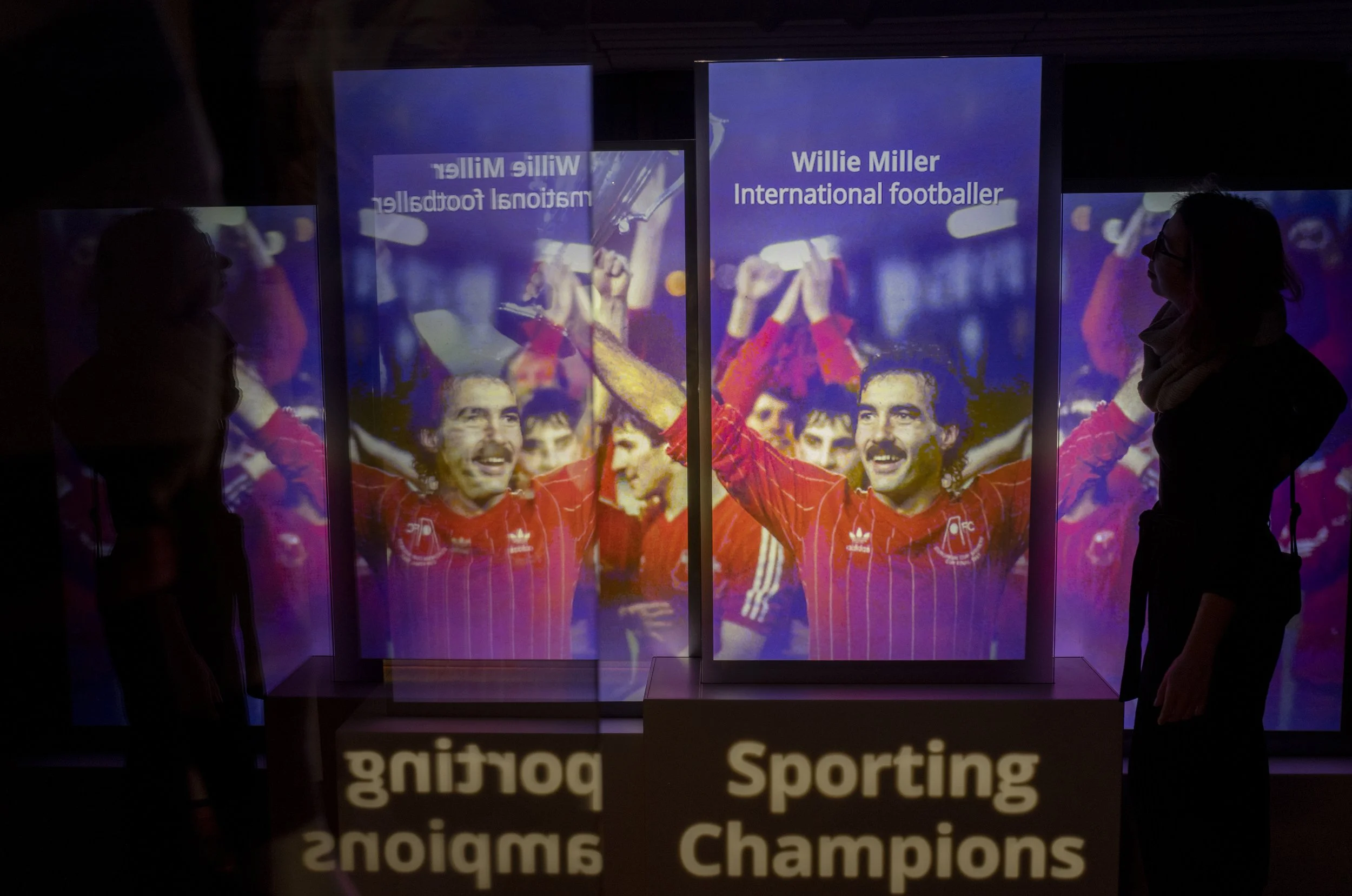 a woman watches a video installation at a museum by Bright Side Studios