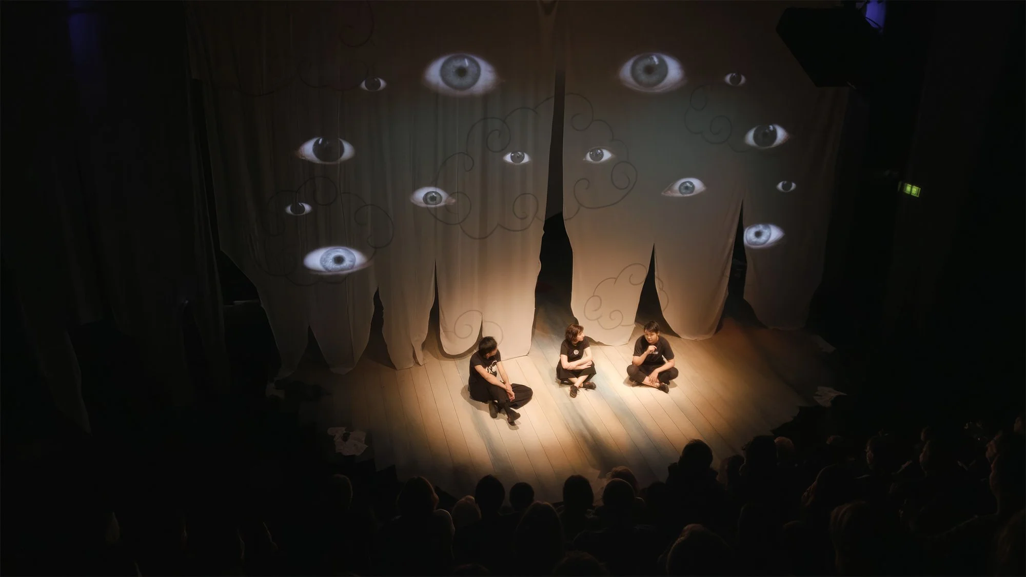 Audience watching live projection mapping and immersive theatre at Traverse Theatre Edinburgh, Strange Tales by Grid Iron Theatre