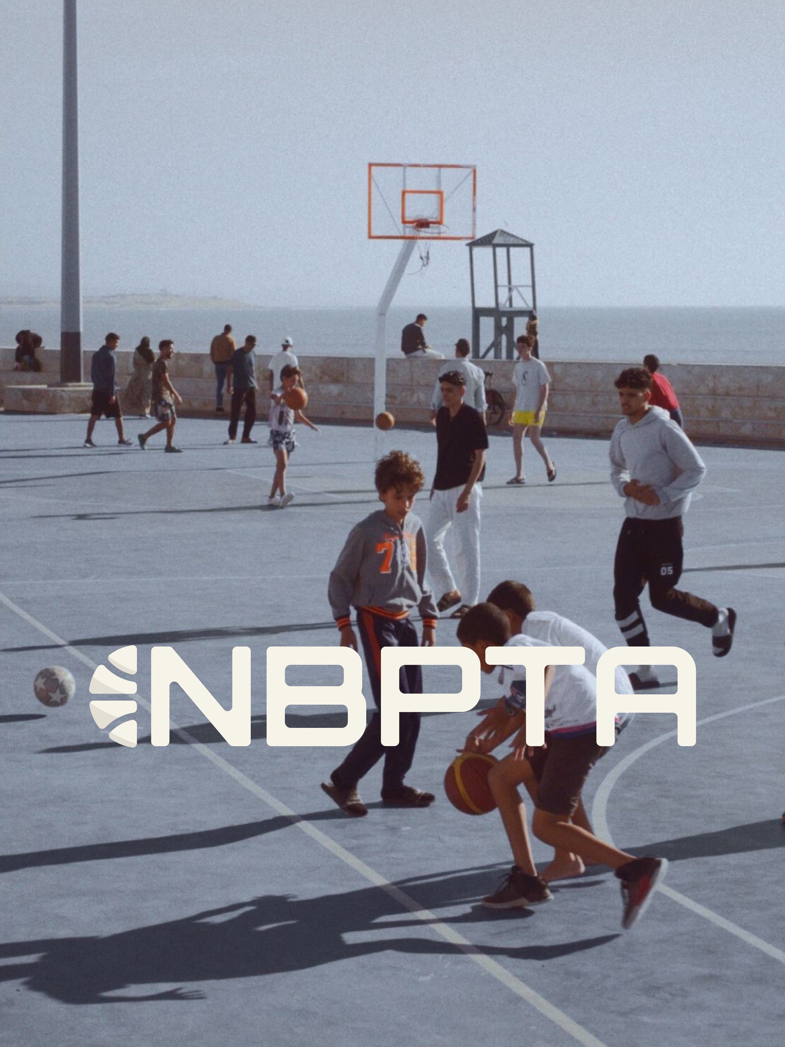 nbpta logo placed on top of background of kids playing basketball at an outdoor court