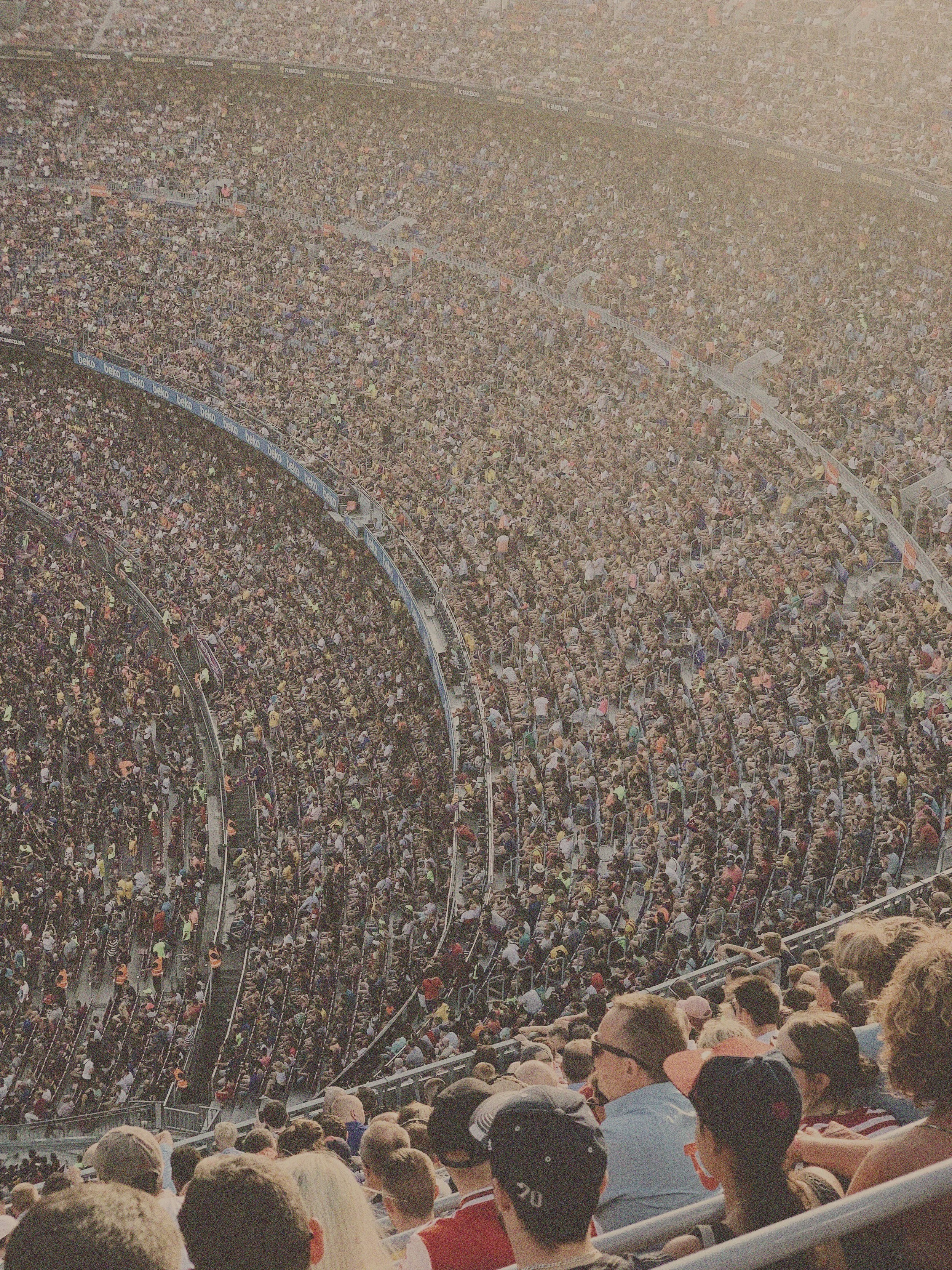 Crowded outdoor stadium filled with spectators watching a sporting event.