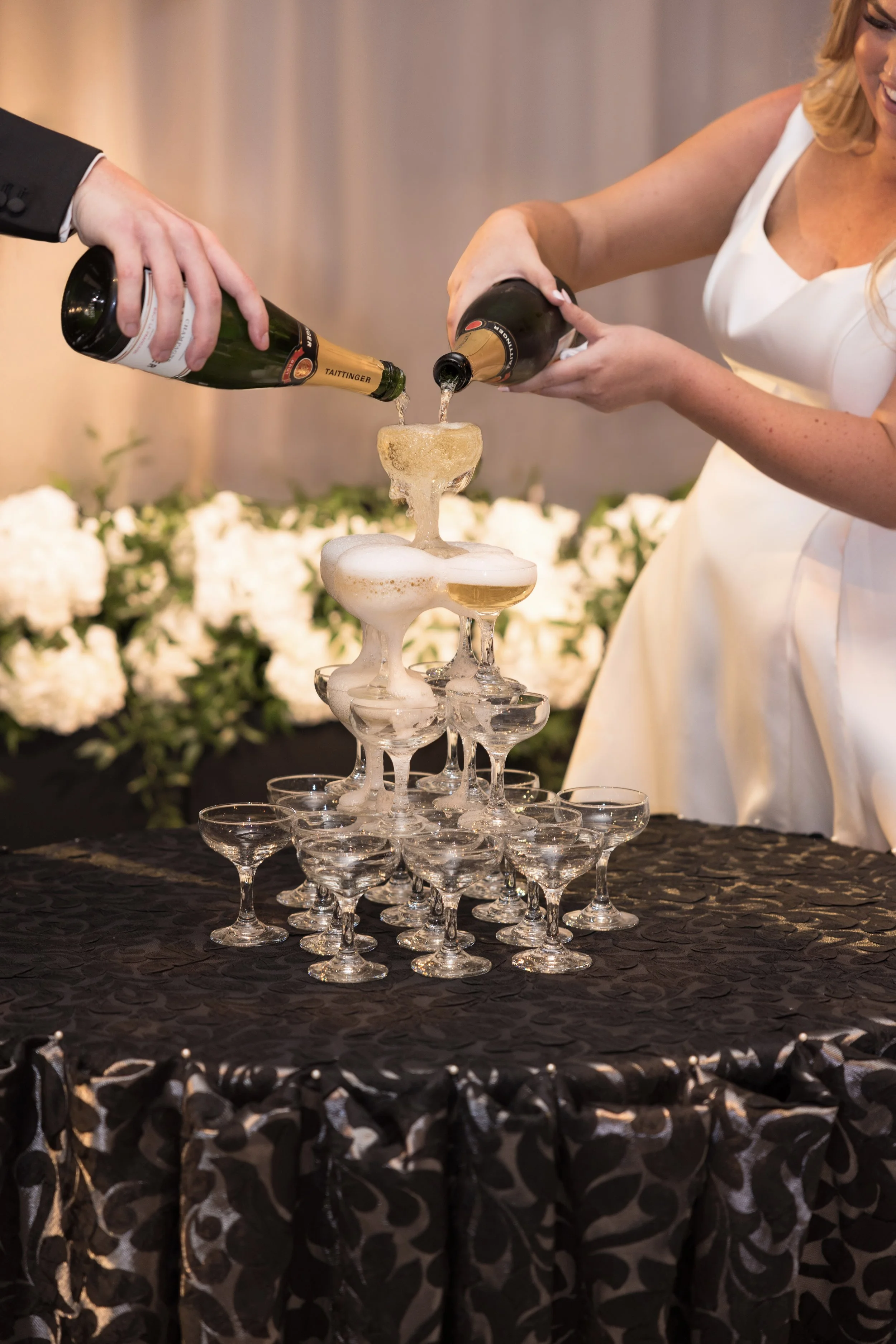 bride and groom pouring champagne into a tower of glasses at a chicago wedding reception