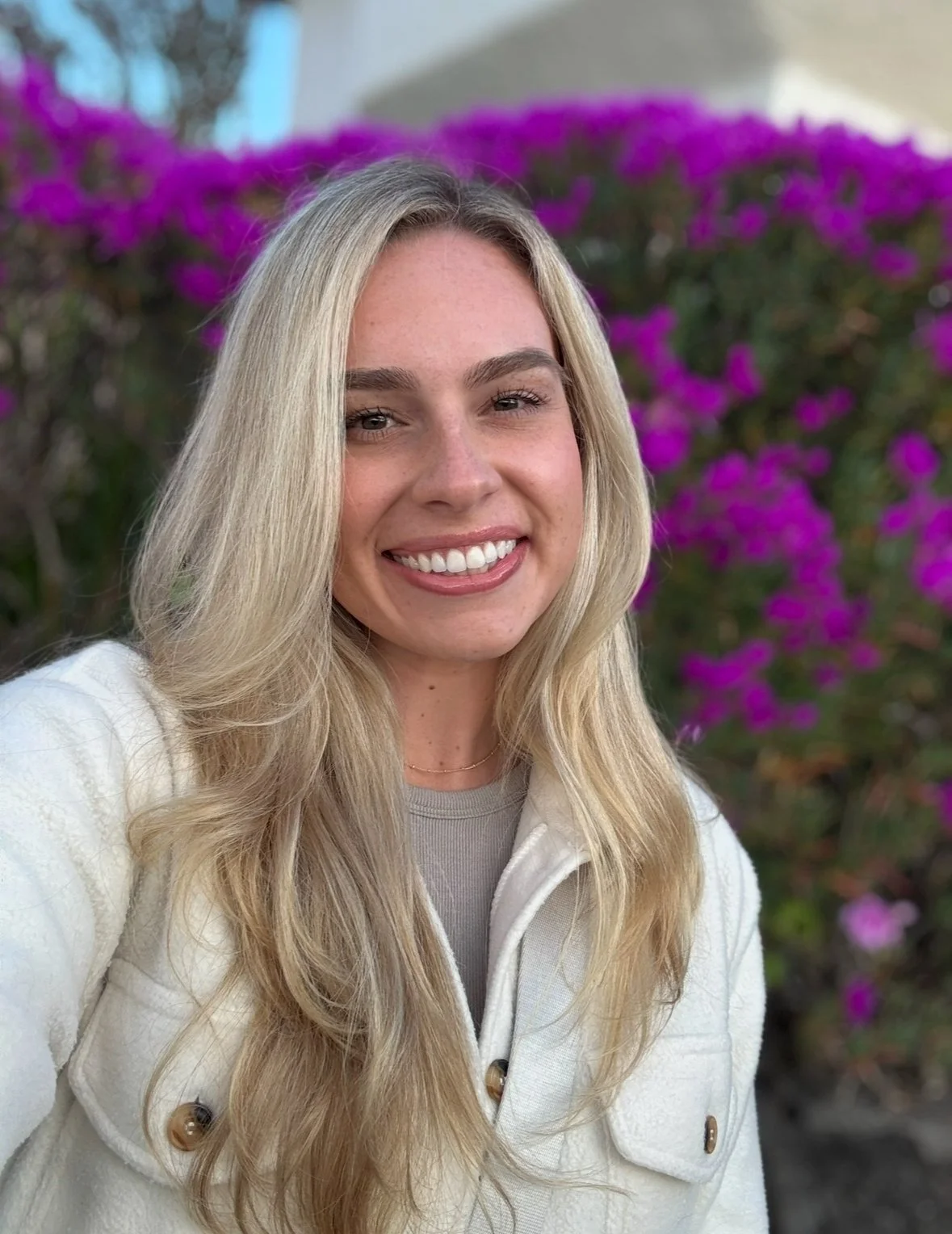 Stephanie, RSMD’s newest registered nurse and focus group member, smiling outdoors with purple flowers in the background.