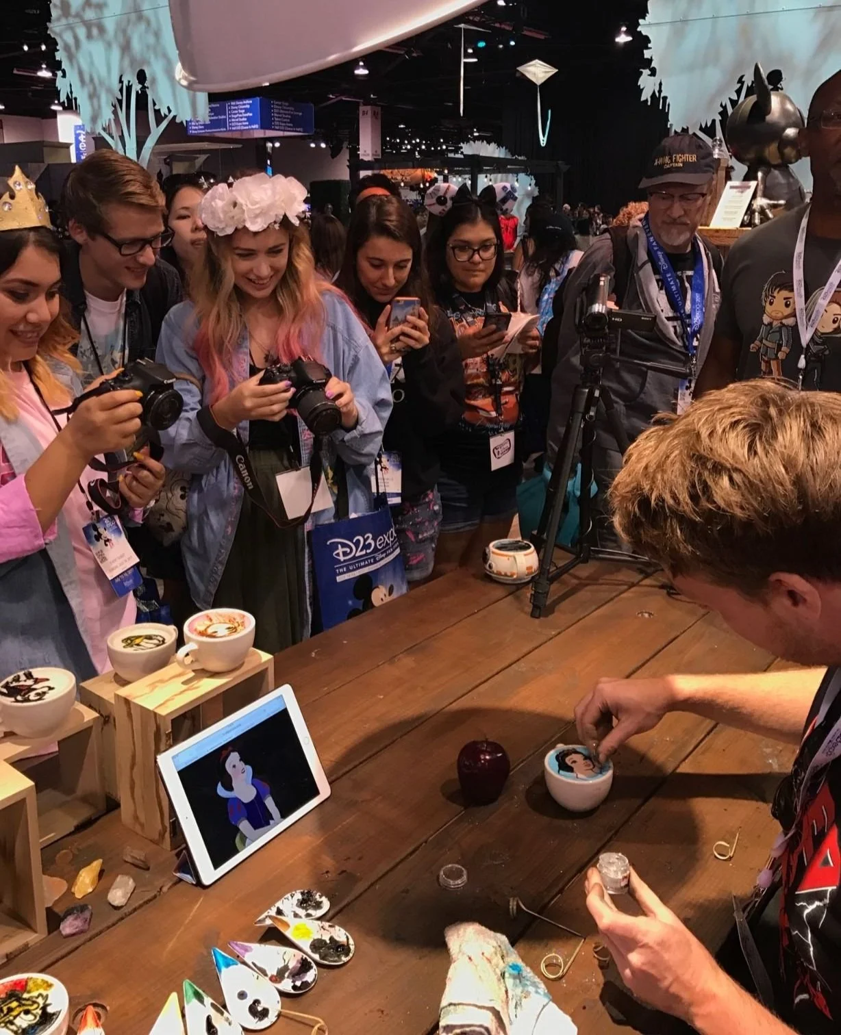 People watching BaristArt create latte art of snow white
