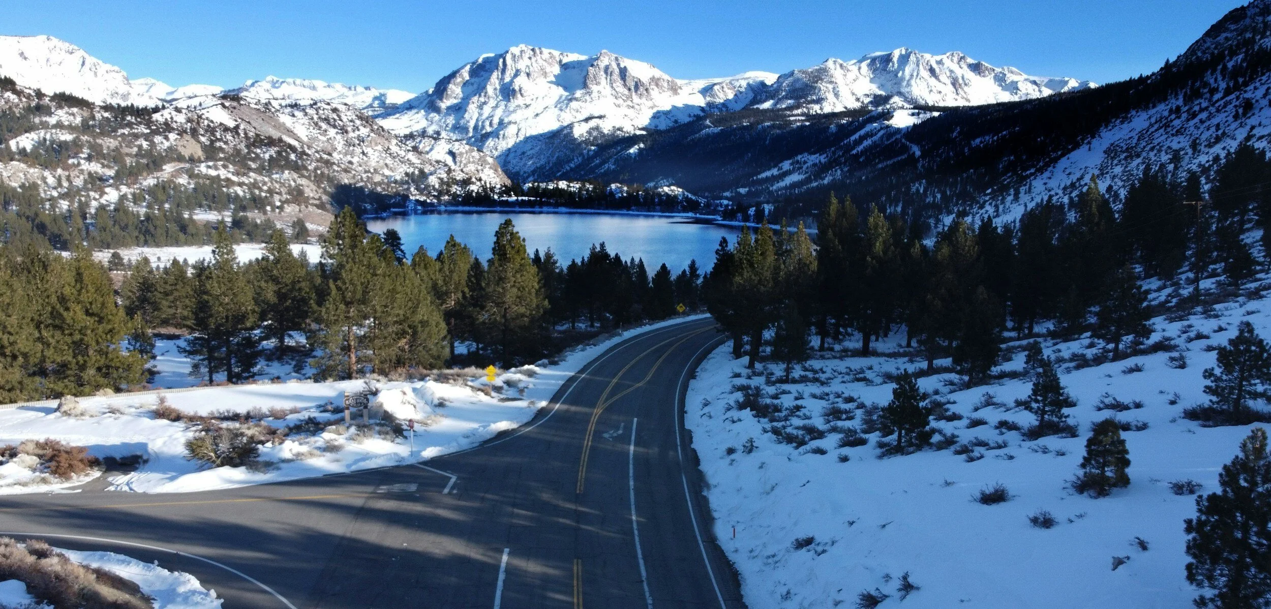 Mountain road with snowy landscape and lake