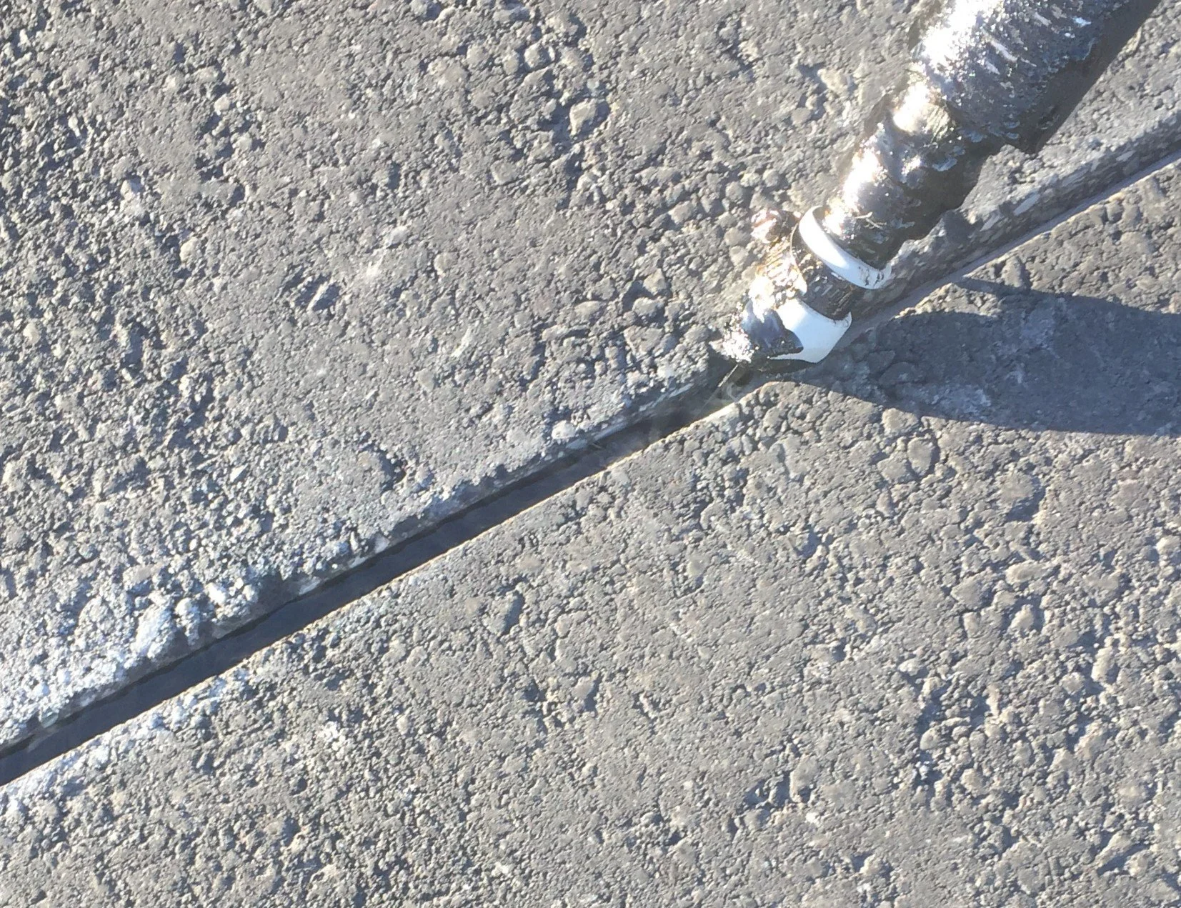 close-up of asphalt crack filling with sealant