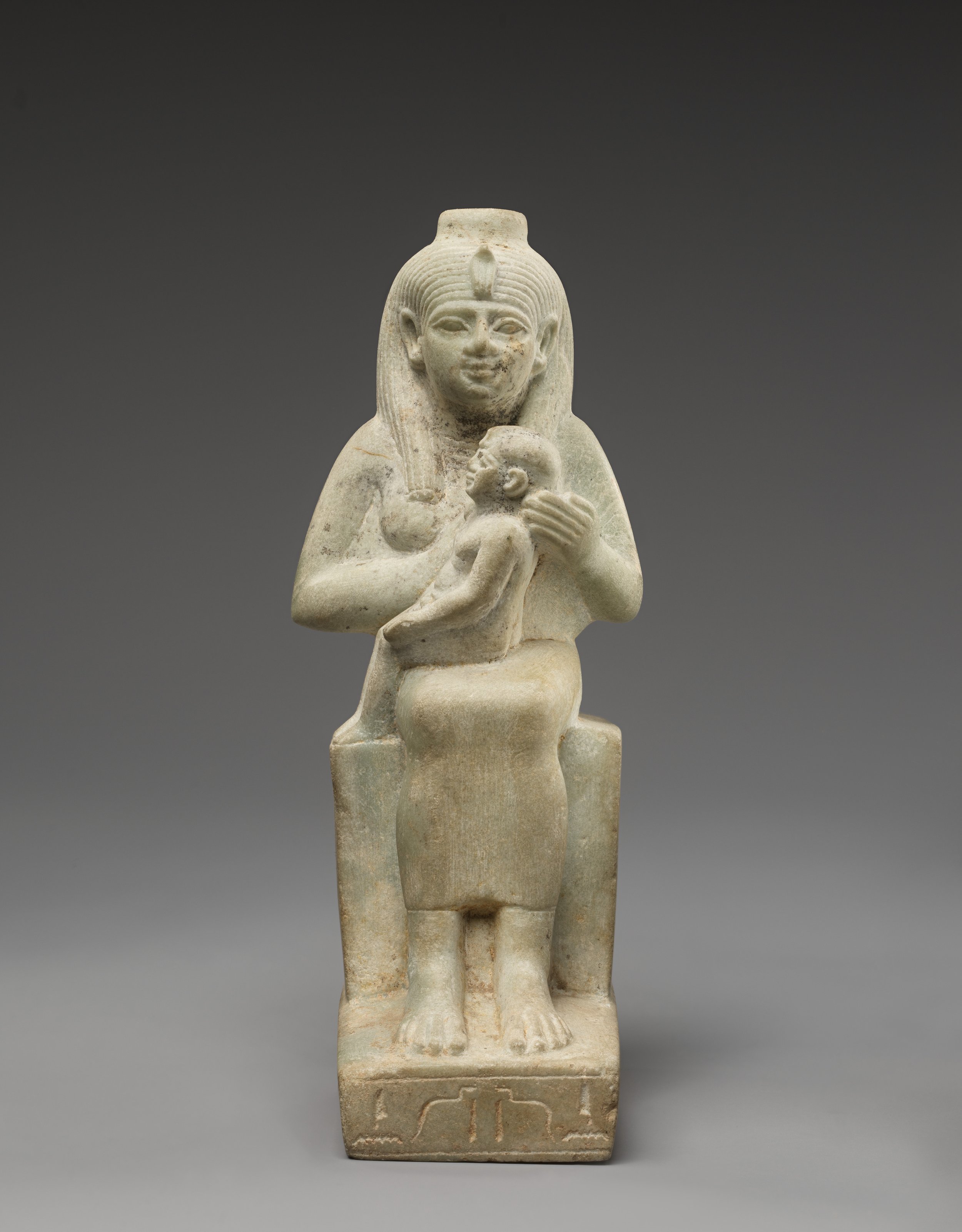Ancient Egyptian statue of Isis protecting and nursing the infant Horus
