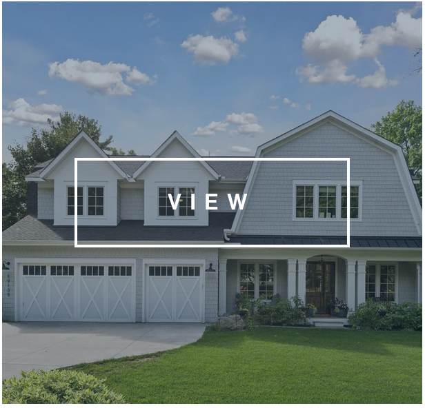 Home facade with gambrel roof, front porch, and three car white carriage house garage doors