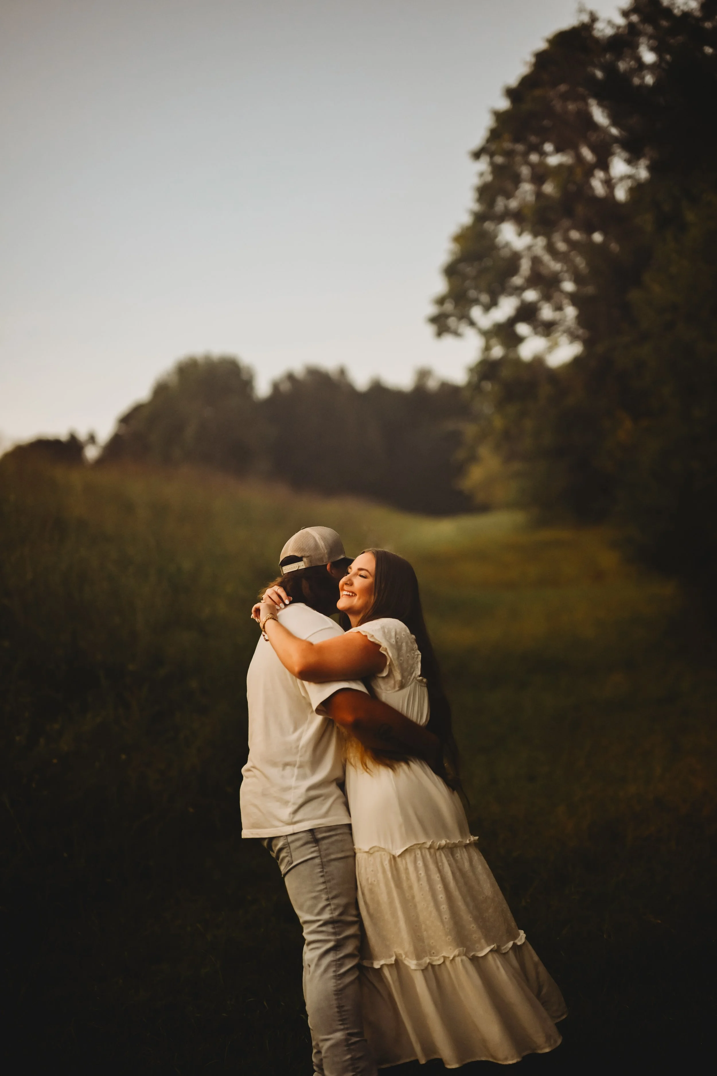 Romantic couple portrait outdoors in a field during golden hour.