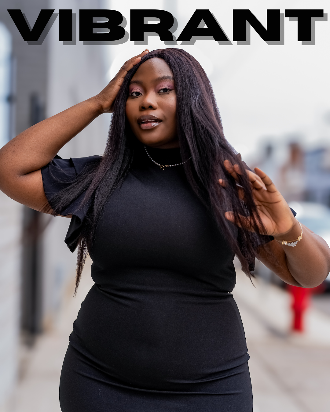 Portrait of a confident woman with long dark hair wearing a black dress, standing outdoors on a city street, with the word 'VIBRANT' in bold above her.