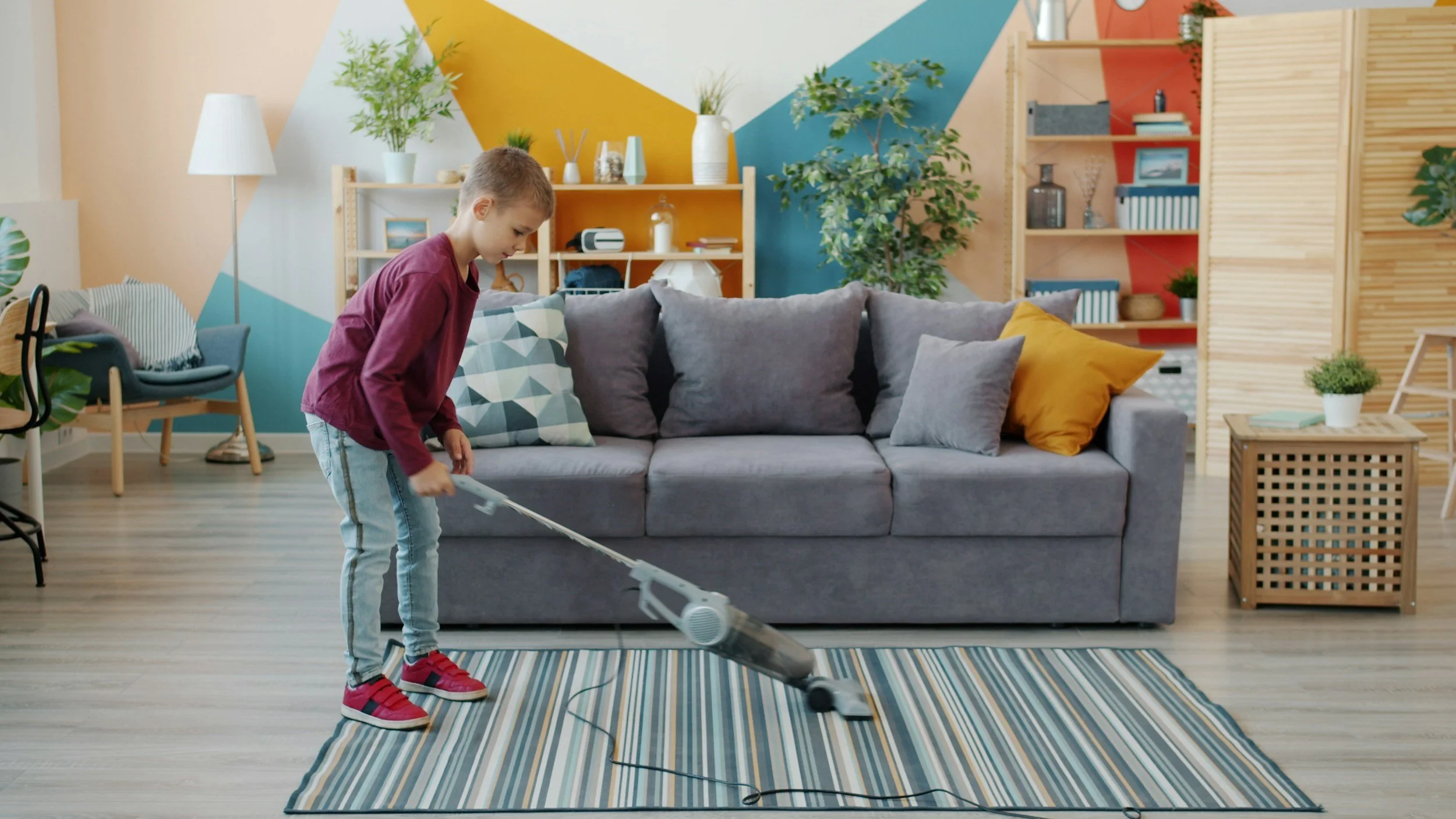 a boy vacuums a rug