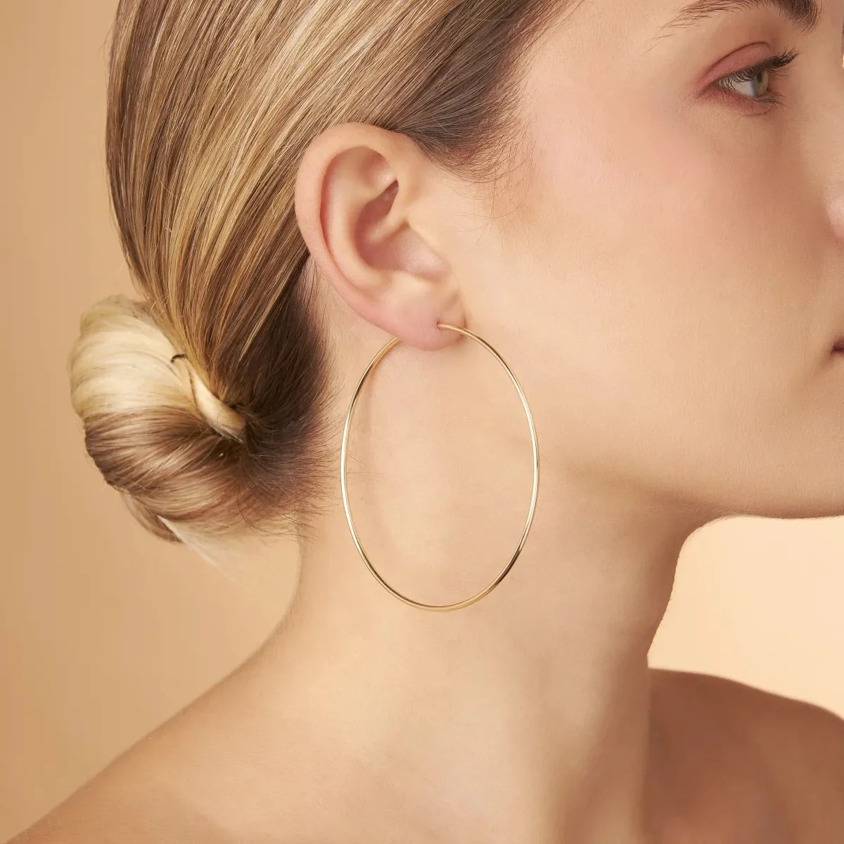 Luxe Sparkles LS-E031 yellow gold hoop earrings, worn by a model